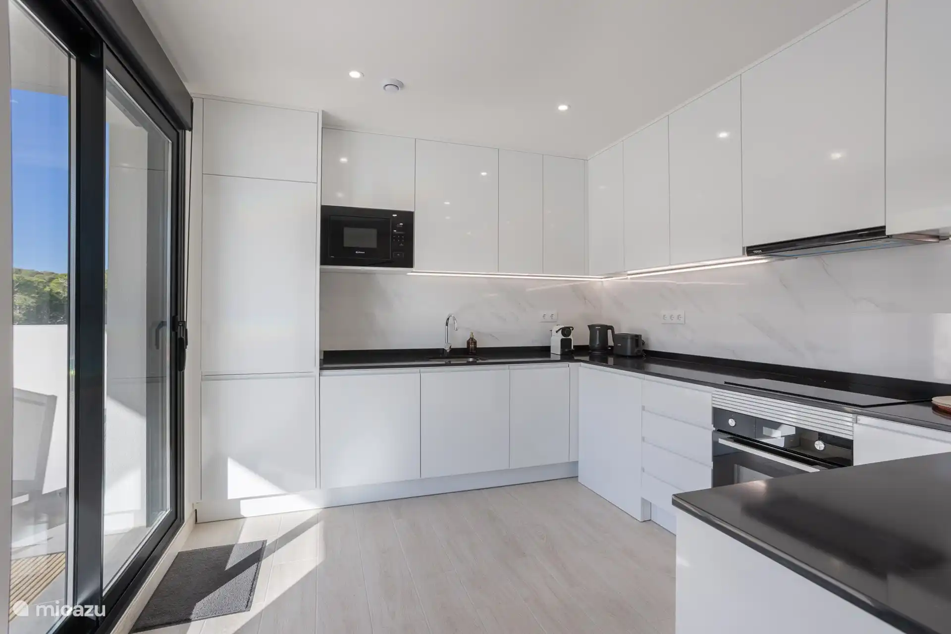 Cuisine moderne avec tous les appareils électroménagers et machine à café Nespresso, grille-pain et bouilloire