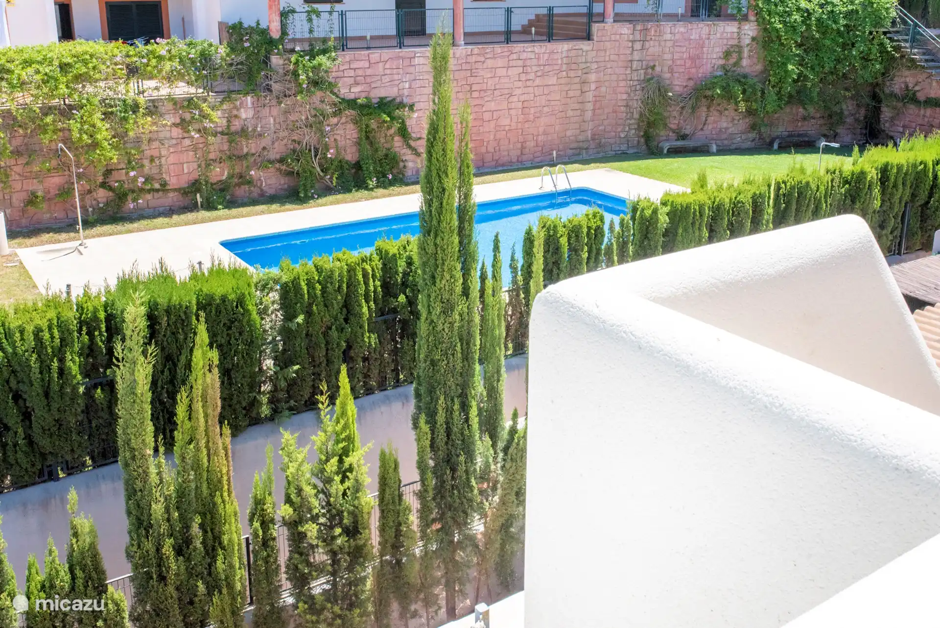 La piscine avec douche extérieure est située directement derrière le jardin