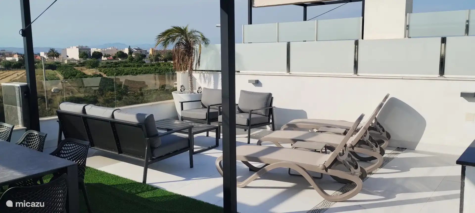 Lounge-Set und Sonnenliegen auf der Dachterrasse