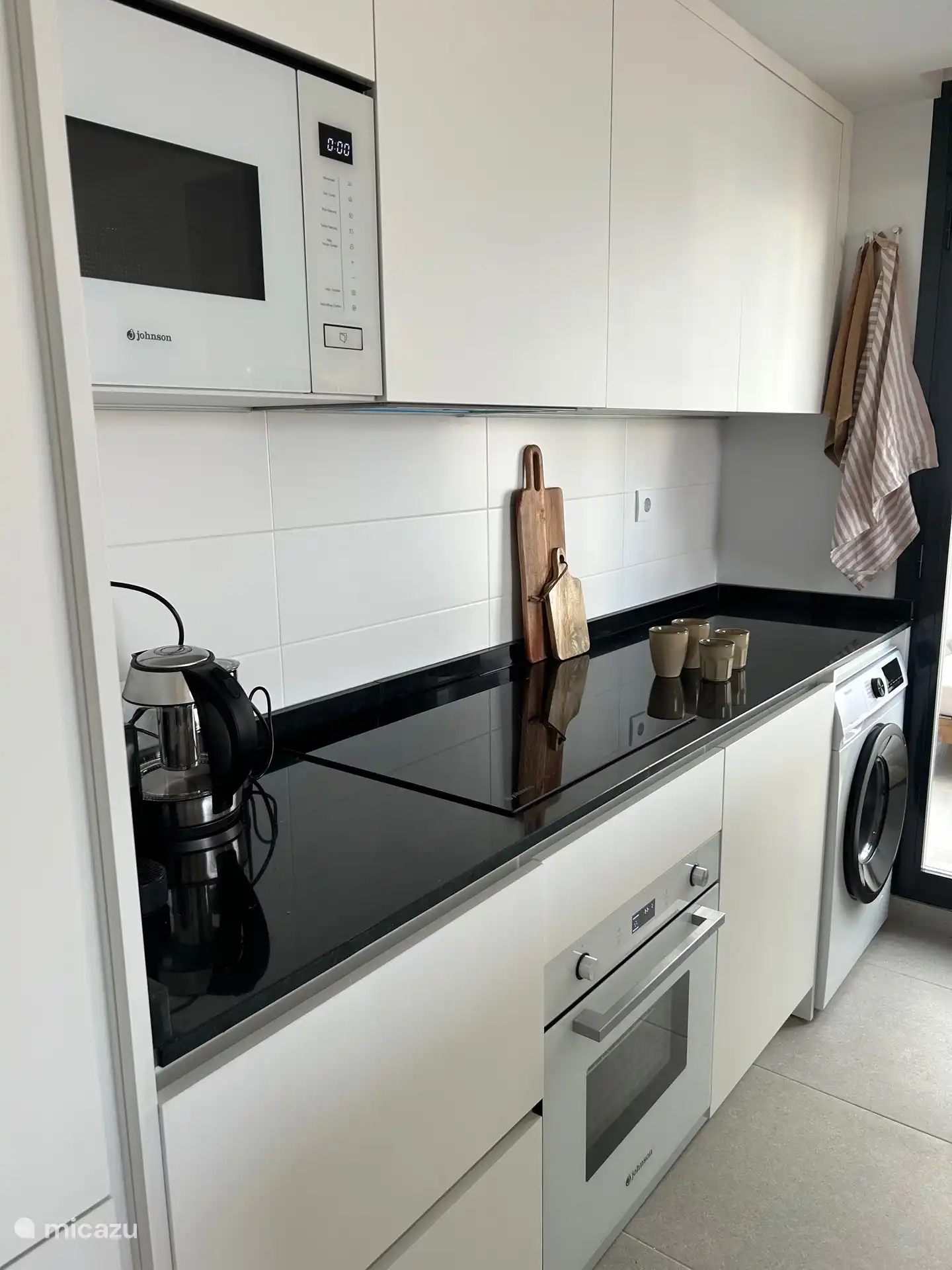 Cocina abierta incluyendo isla con instalaciones de lujo, como microondas combinado, horno, vitrocerámica, lavavajillas, lavadora, nevera-congelador, cafetera Nespresso con aeroccino y agua potable (Spa Blue) del grifo, etc.