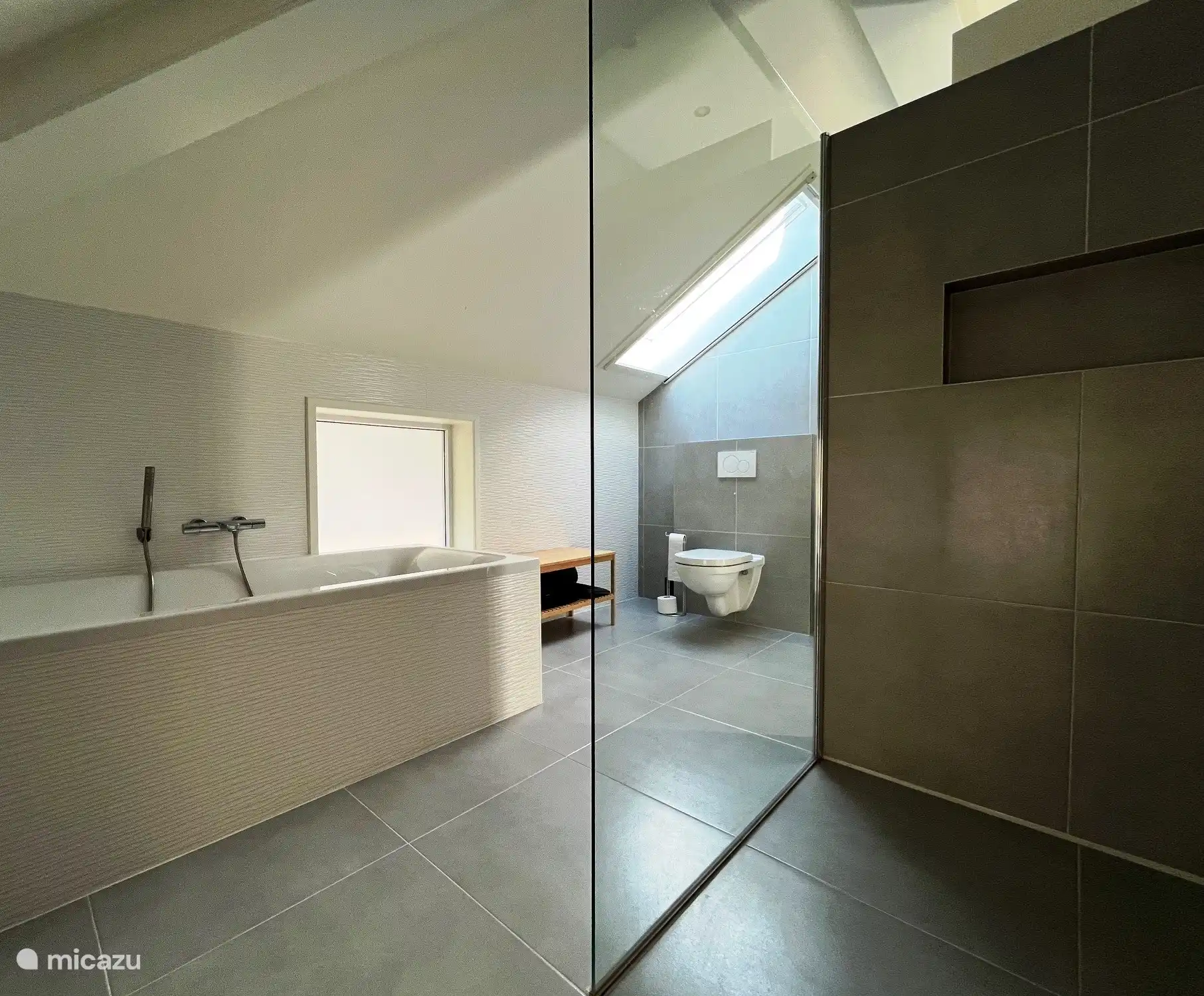 Luxuriöses Badezimmer mit Badewanne, geräumiger Dusche, WC und Doppelwaschbecken