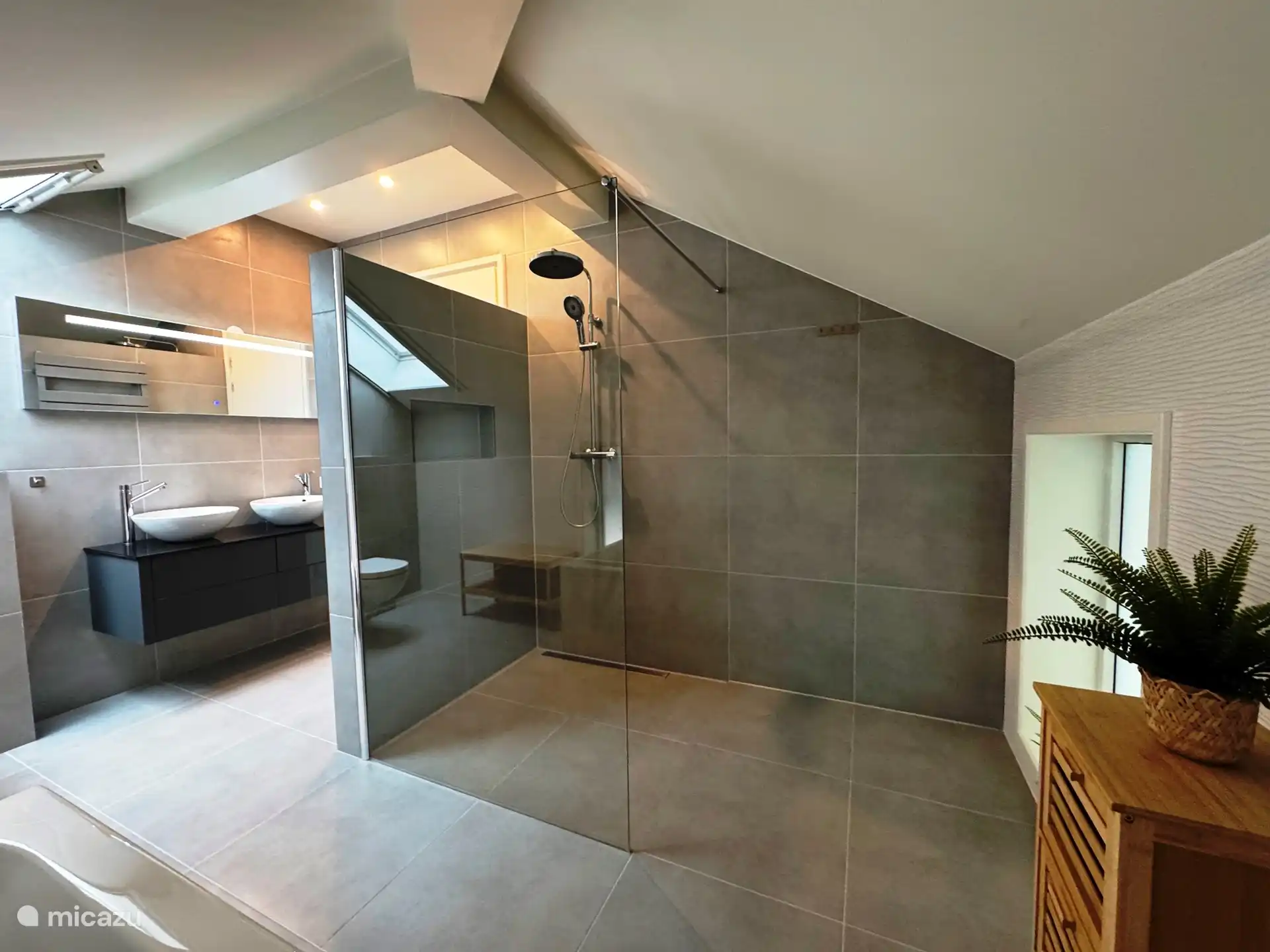 Badezimmer mit Regendusche, Badewanne, WC und Doppelwaschbecken