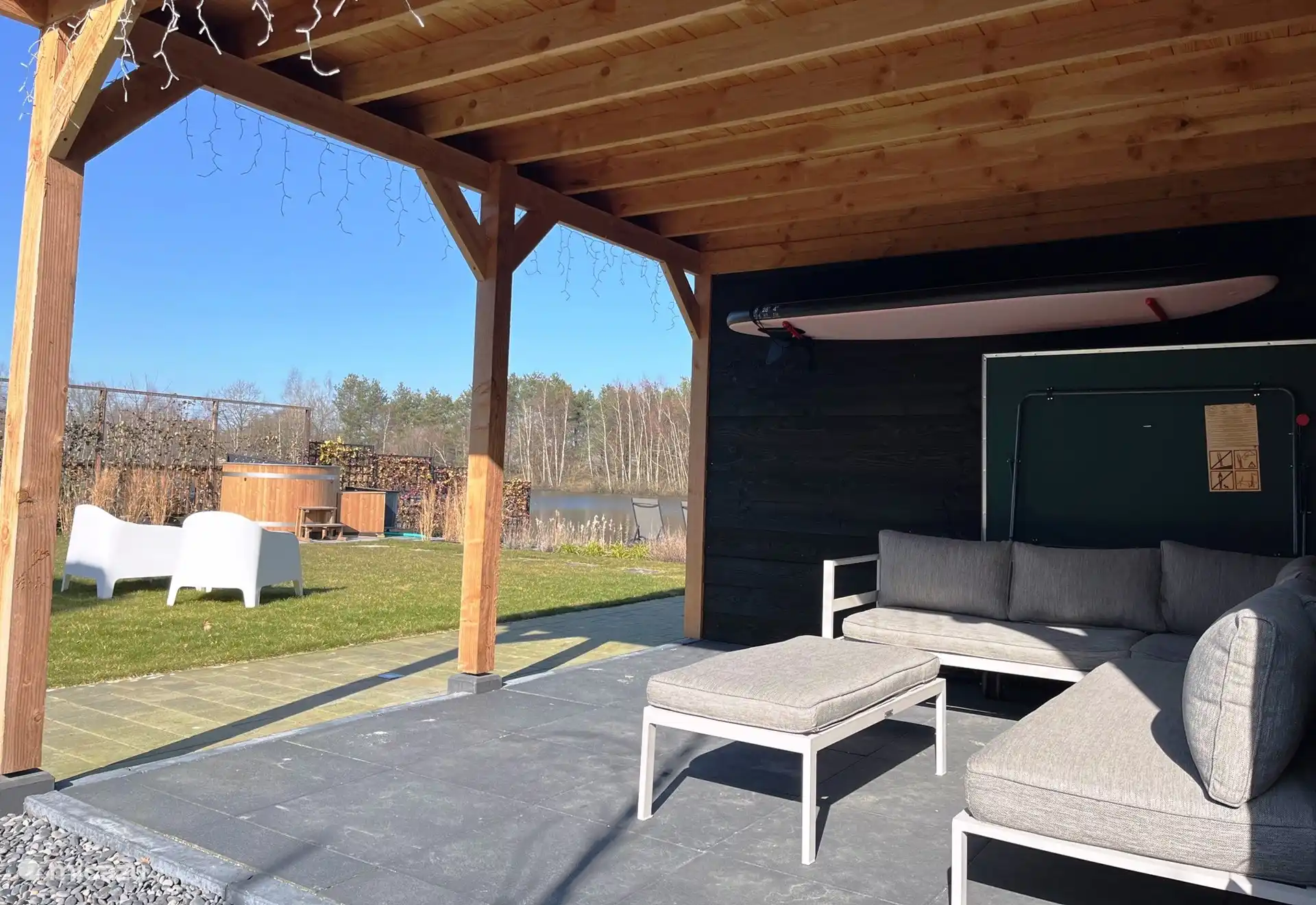 Überdachte Terrasse auf der Rückseite mit Lounge-Set.
Es gibt auch eine (ausklappbare) Tischtennisplatte und ein SUP