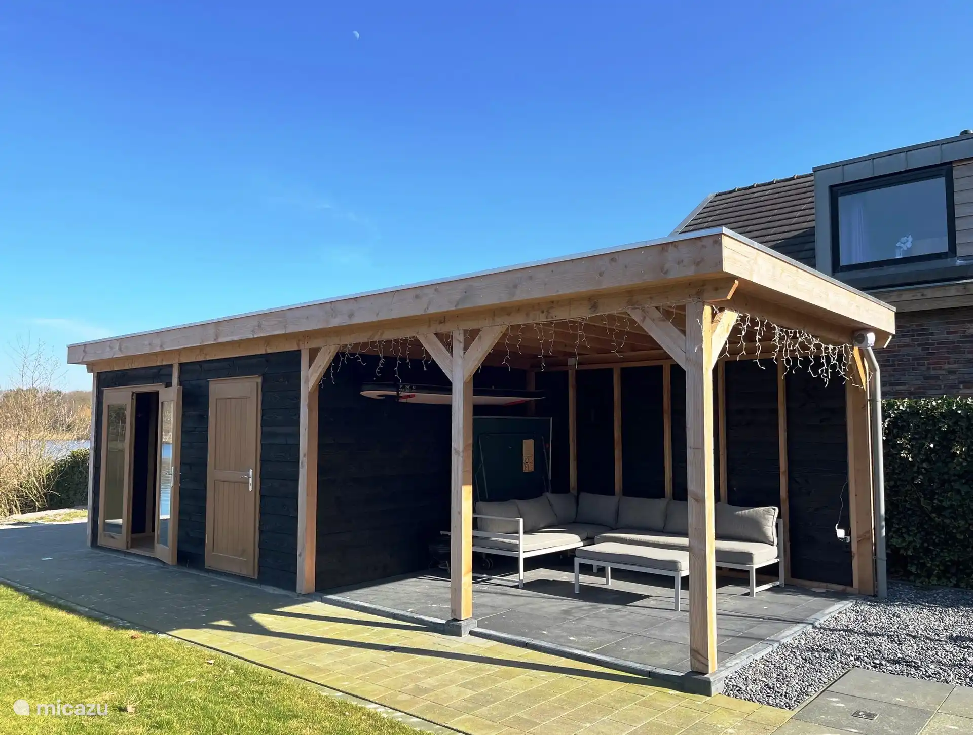 Überdachte Terrasse mit Lounge-Set. Sup und (klappbare) Tischtennisplatte. Daneben befindet sich die Sauna