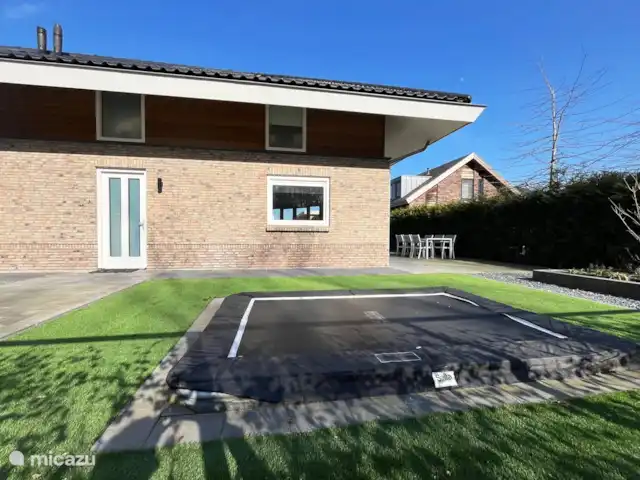 Crécerelle | Pays-Bas, Overijssel, Sibculo - maison de vacances Devant de la maison, avec une haute haie et un portail séparés de la cour. Les enfants peuvent jouer sur le trampoline.