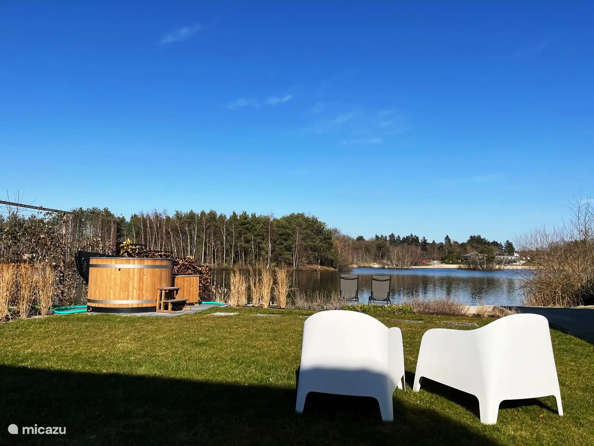 Großer Garten auf der Rückseite des Hauses mit direktem Zugang zum See. Mit einem eigenen Strand und einem Whirlpool.