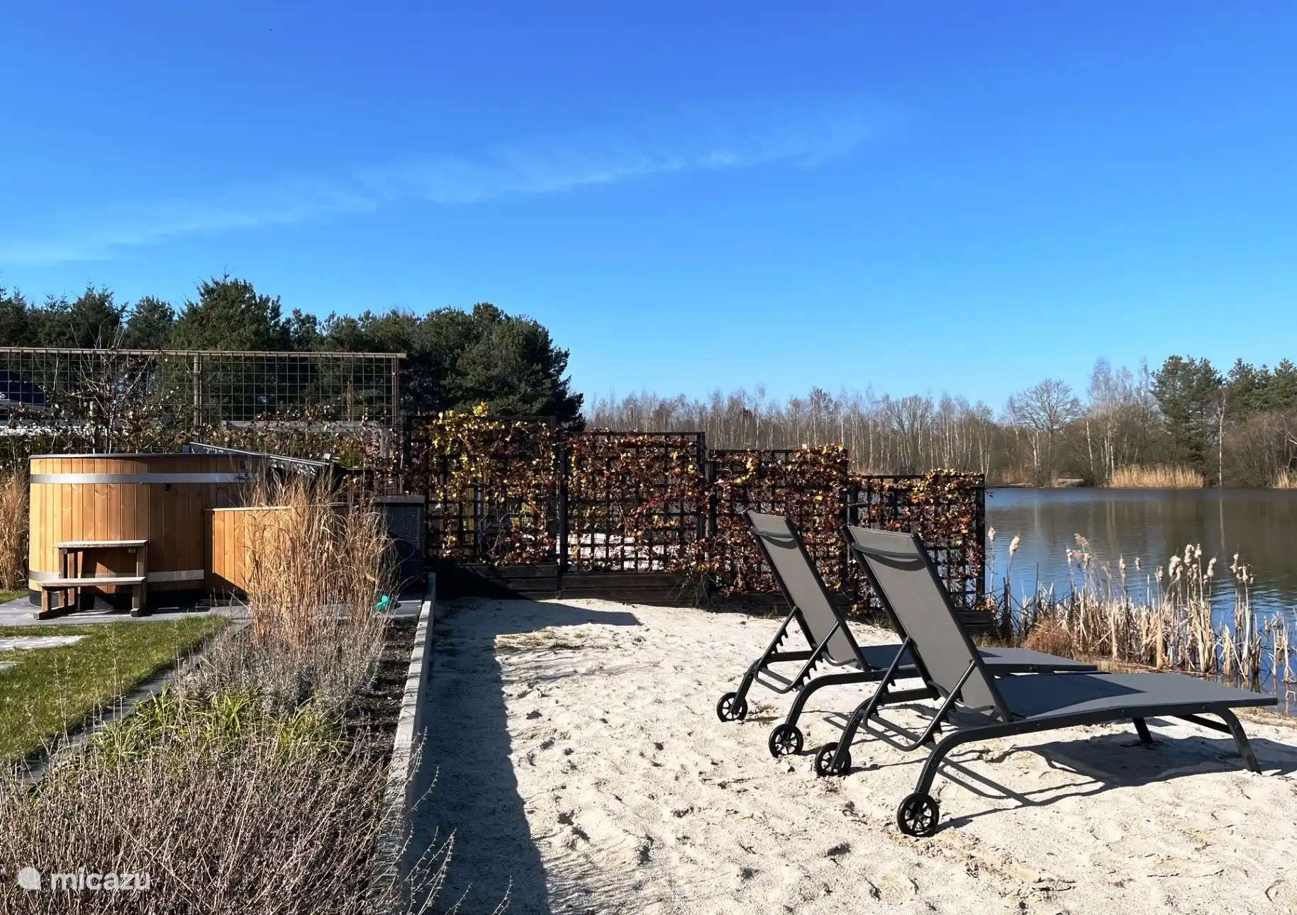 Rückseite des Hauses mit Strand, Liegestühlen und elektrischem Whirlpool.