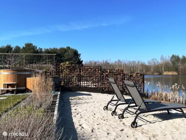 Crécerelle | Pays-Bas, Overijssel, Sibculo - maison de vacances Arrière de la maison avec une plage, des chaises longues et un bain à remous électrique.