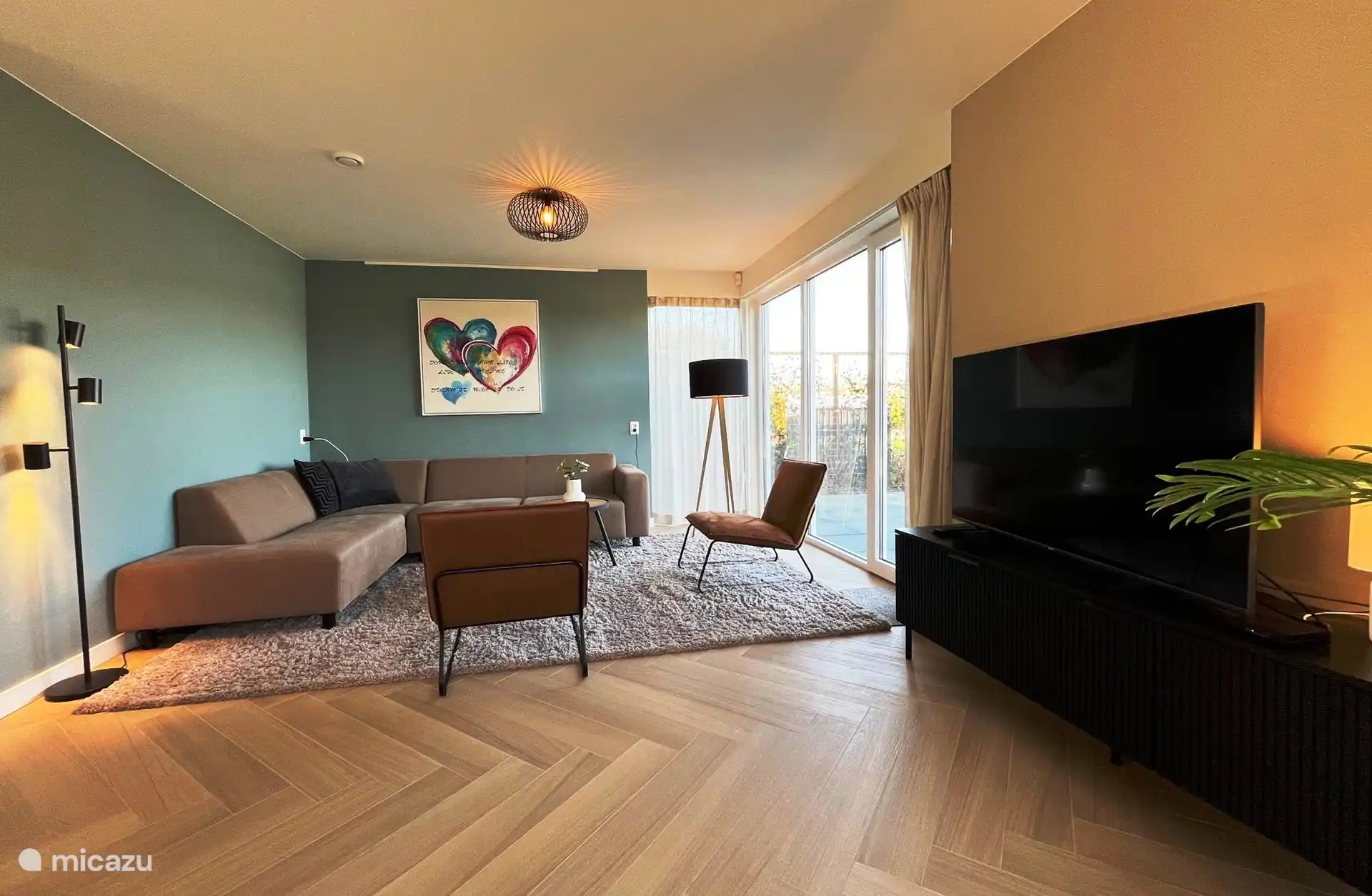 Loungebereich mit Blick auf die Terrasse, den Garten und das Wasser.