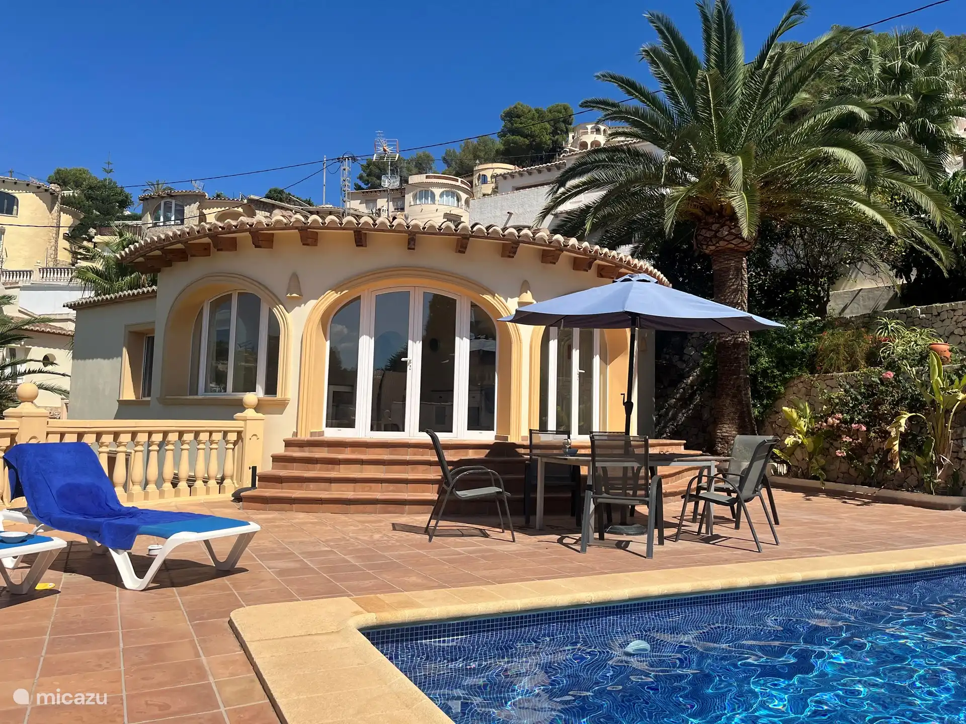 Terrasse mit Sonnenliegen, Palmen und einem entspannenden 8x4 Meter großen Pool