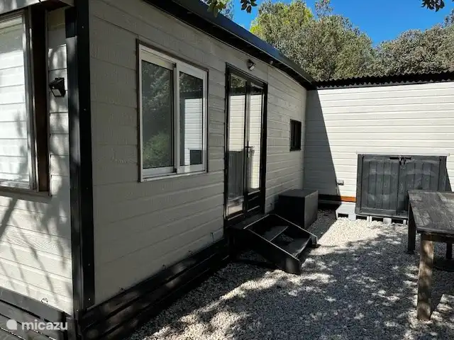 Vacquières, Parc le Duc n° 262 | France, Hérault, Vacquières - chalet L’entrée du chalet à l’arrière, à l’abri des regards de la route. Boîte de rangement avec la machine à laver et une plaque de cuisson supplémentaire pour que vous puissiez également cuisiner à l’extérieur.