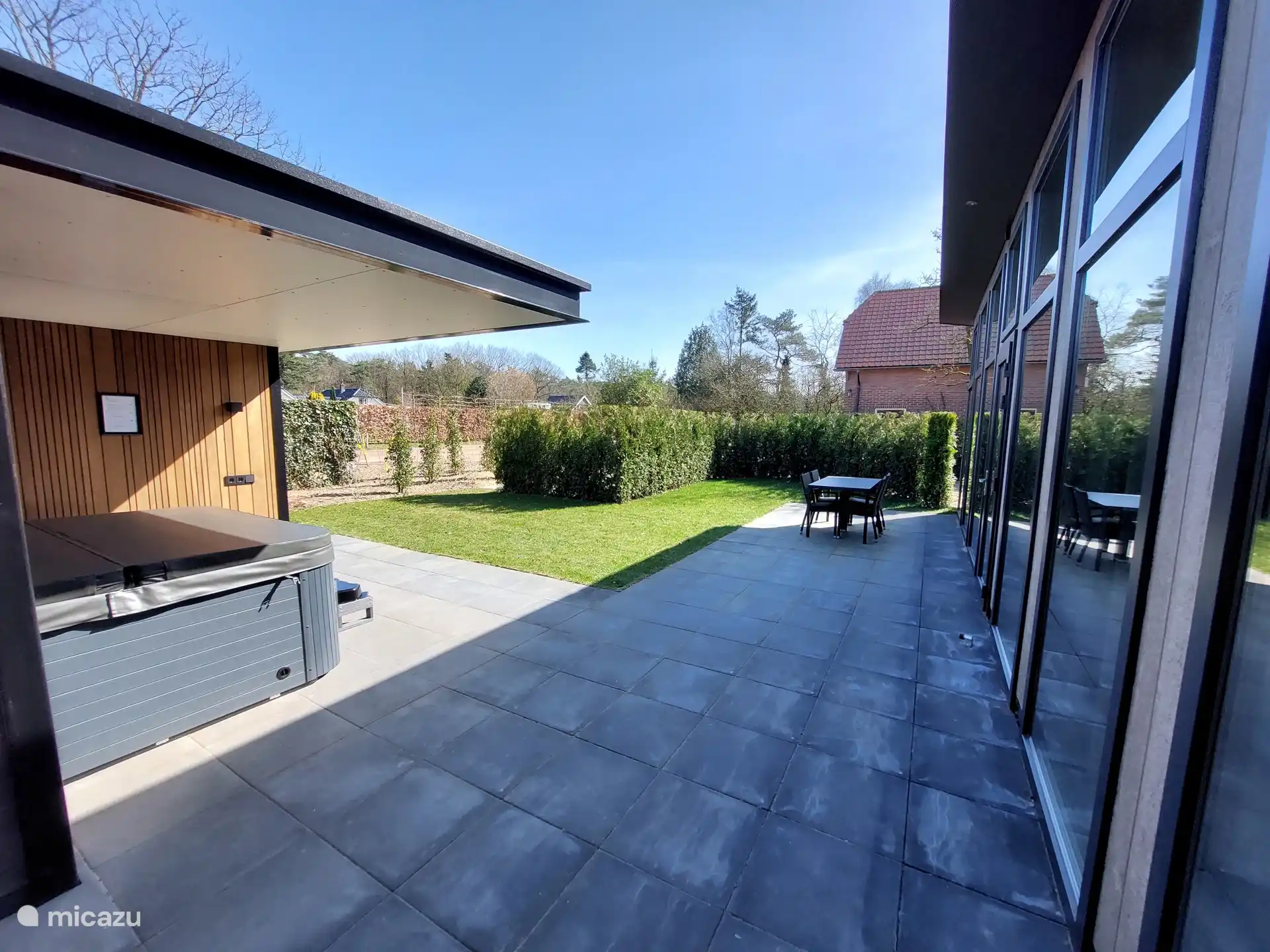 Großzügige Terrasse mit Gartenmöbeln und Sonnenschirm