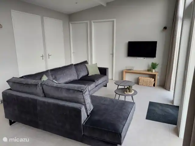 Bungalow confort con jacuzzi 01 en Países Bajos, Güeldres, Putten - casa vacacional Sofá esquinero donde relajarse.