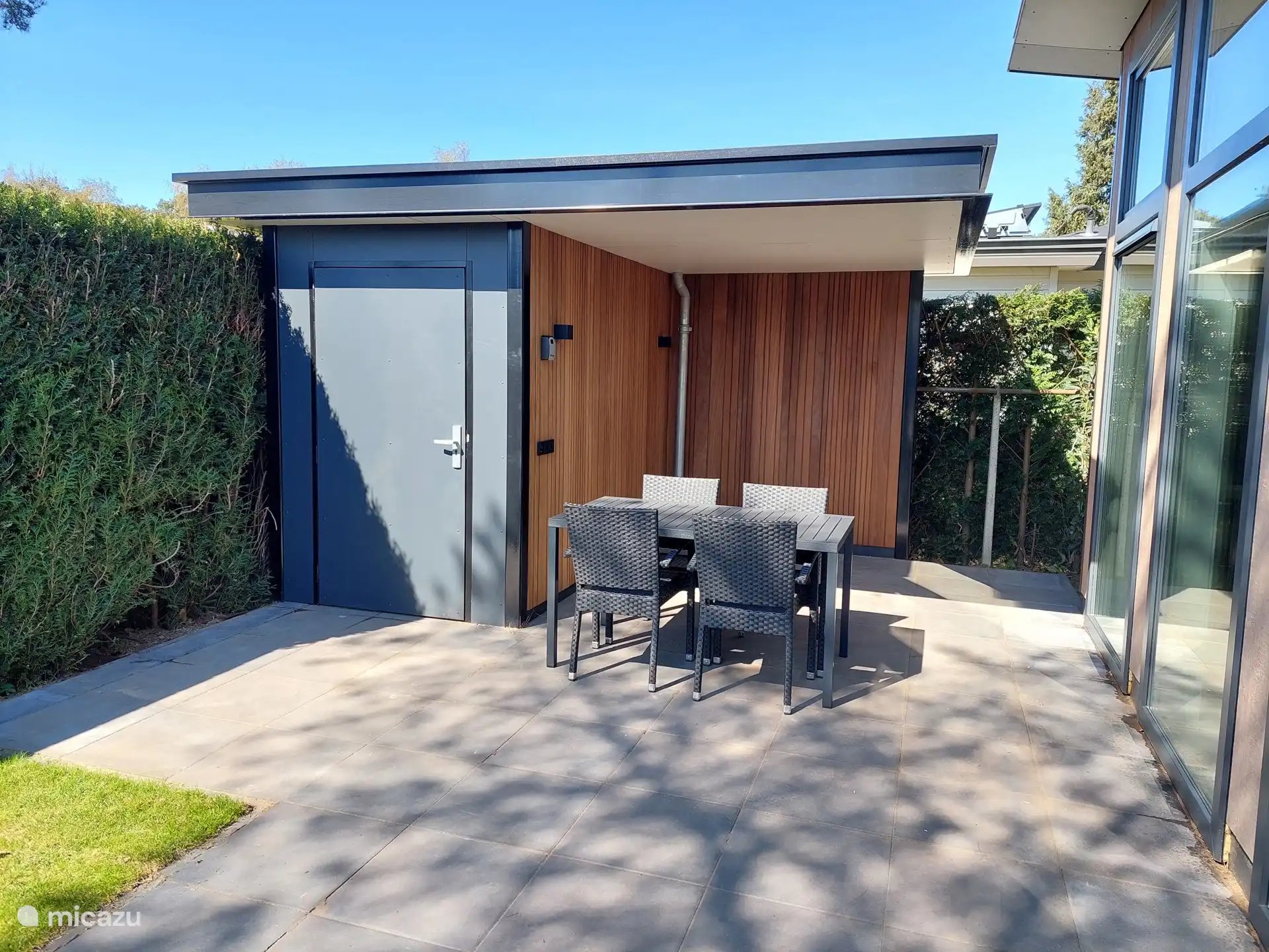 Berging, overkapping en tuinset op het terras