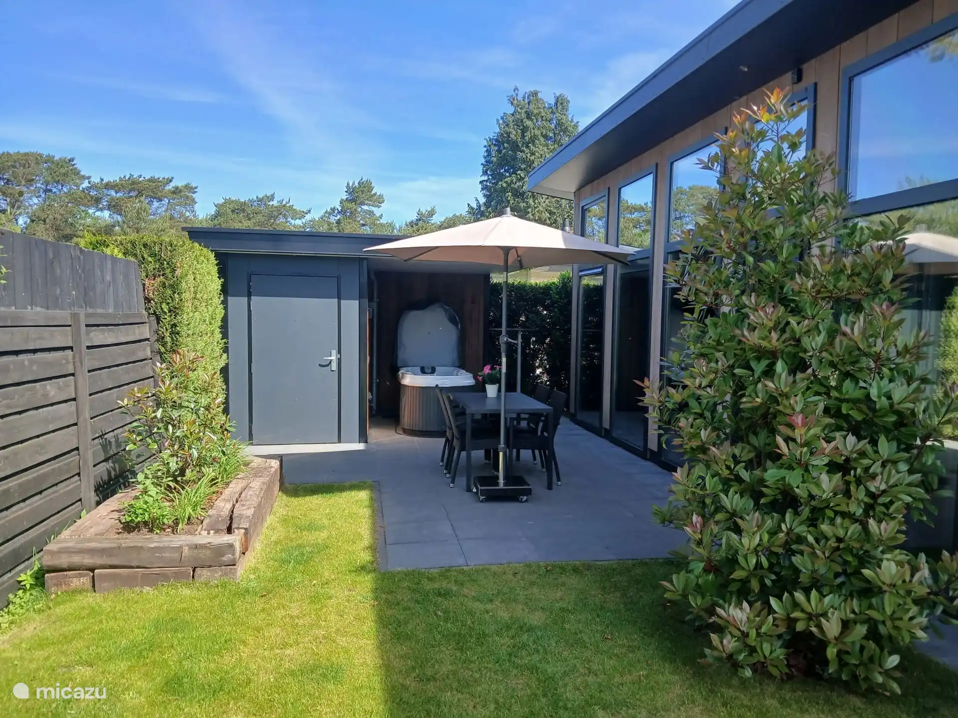 Terras met tuinset, parasol en jacuzzi