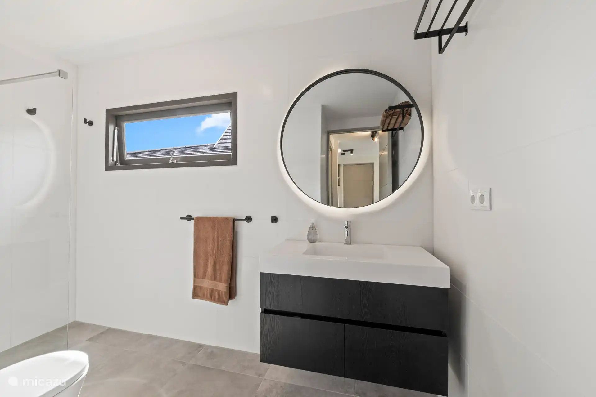 Schönes Badezimmer mit Regendusche, WC und geräumigem Waschbecken