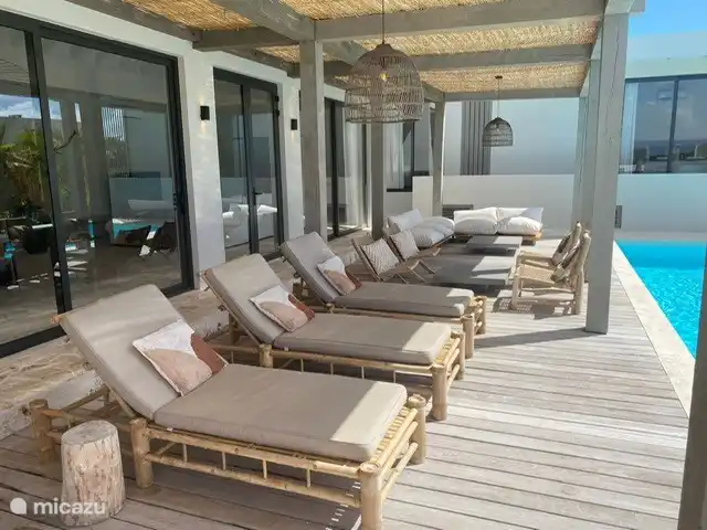 Poolterrasse mit Sonnenliegen, Stühlen und Lounge-Set 