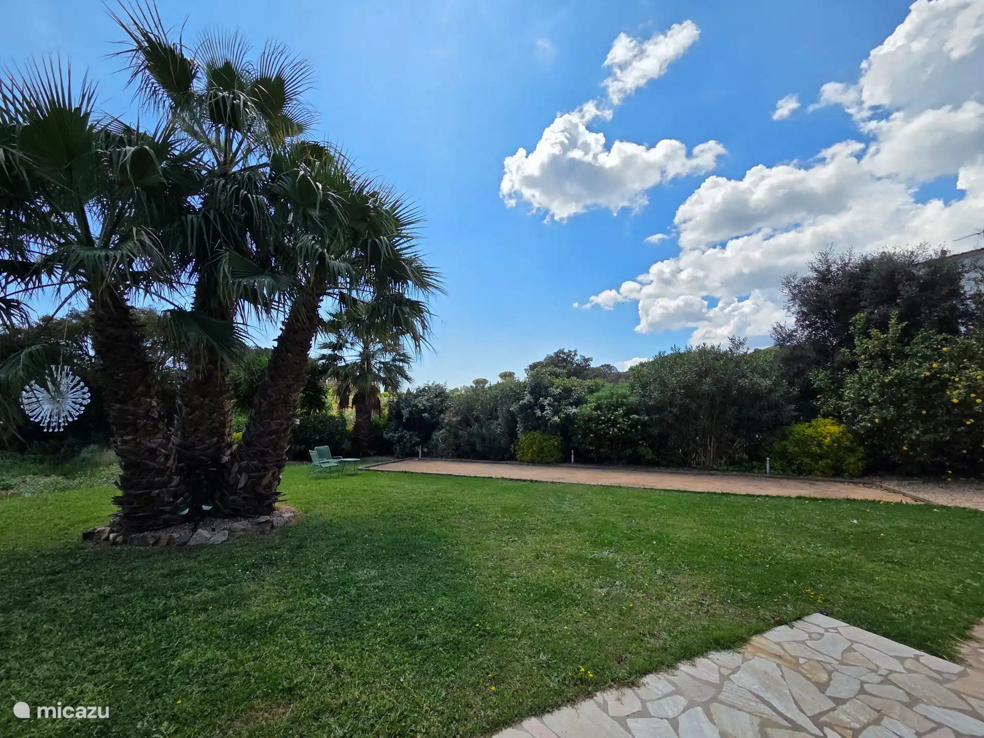 Dans le grand jardin spacieux et plat, il y a un véritable terrain de jeu de boul