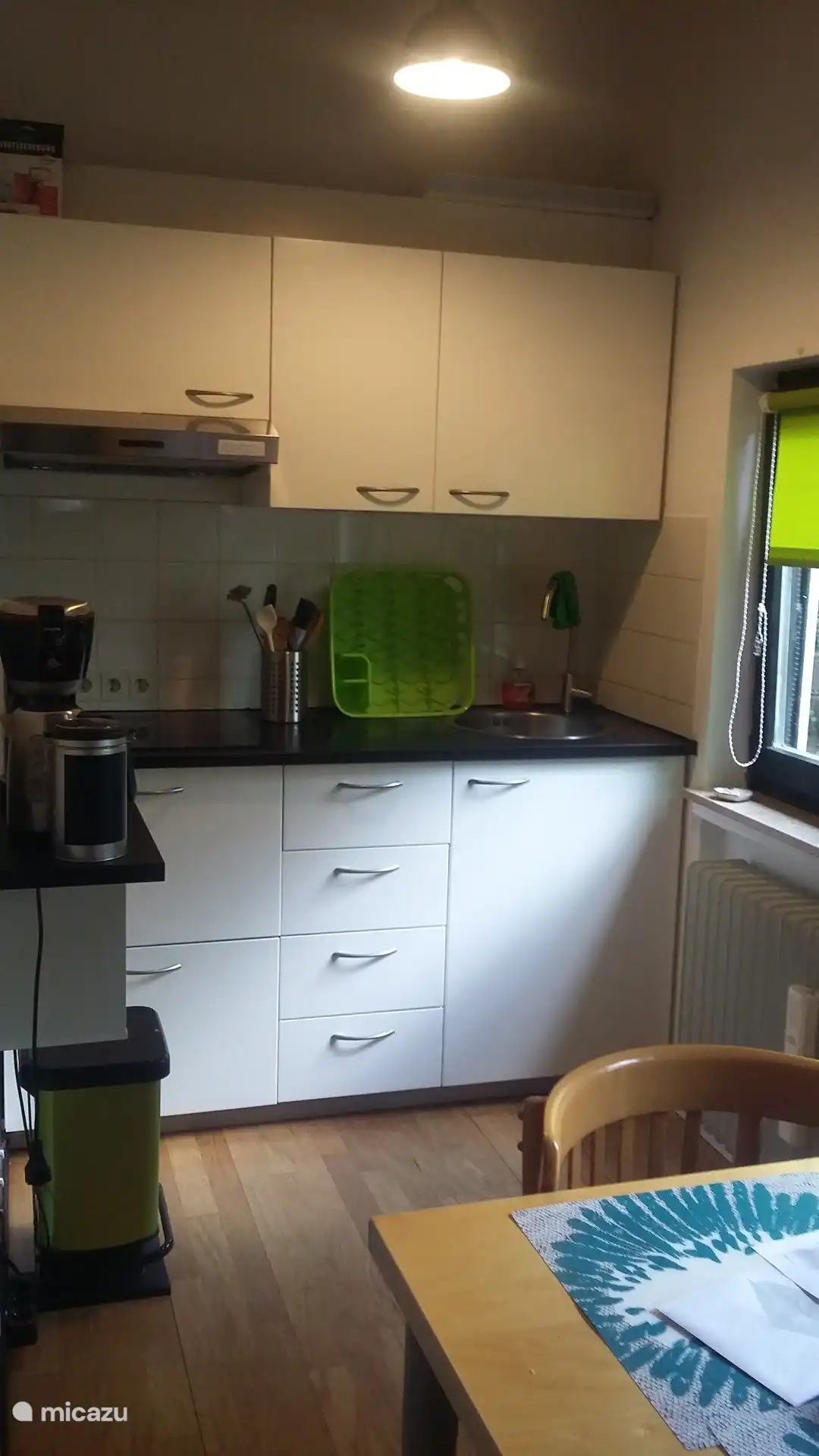 La pequeña cocina tiene una columna separada con horno y una nevera grande (sin compartimento congelador). Hay espacio de almacenamiento adicional en la despensa contigua.