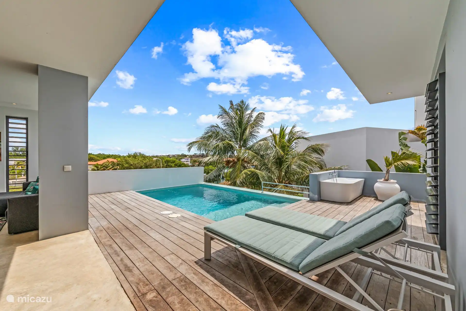 Comfortable ligbedjes aan het zwembad.