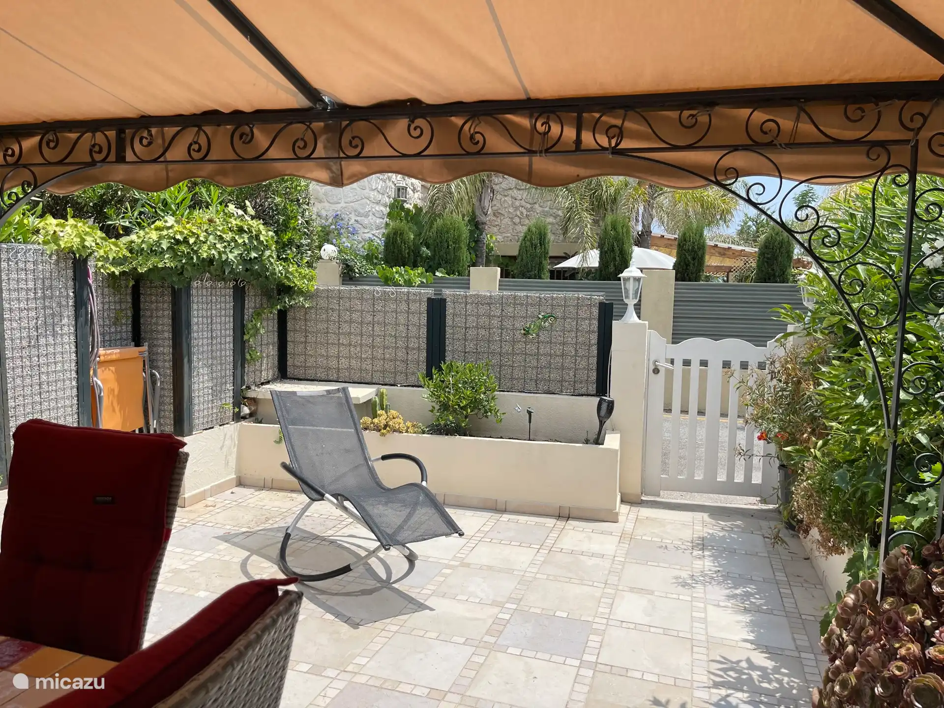 Tuin / terras, zon gedeelte, met uitzicht op villa er achter.