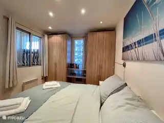 Andere zijde van de grote slaapkamer met wastafel en TV aan de voorkant van het huis.