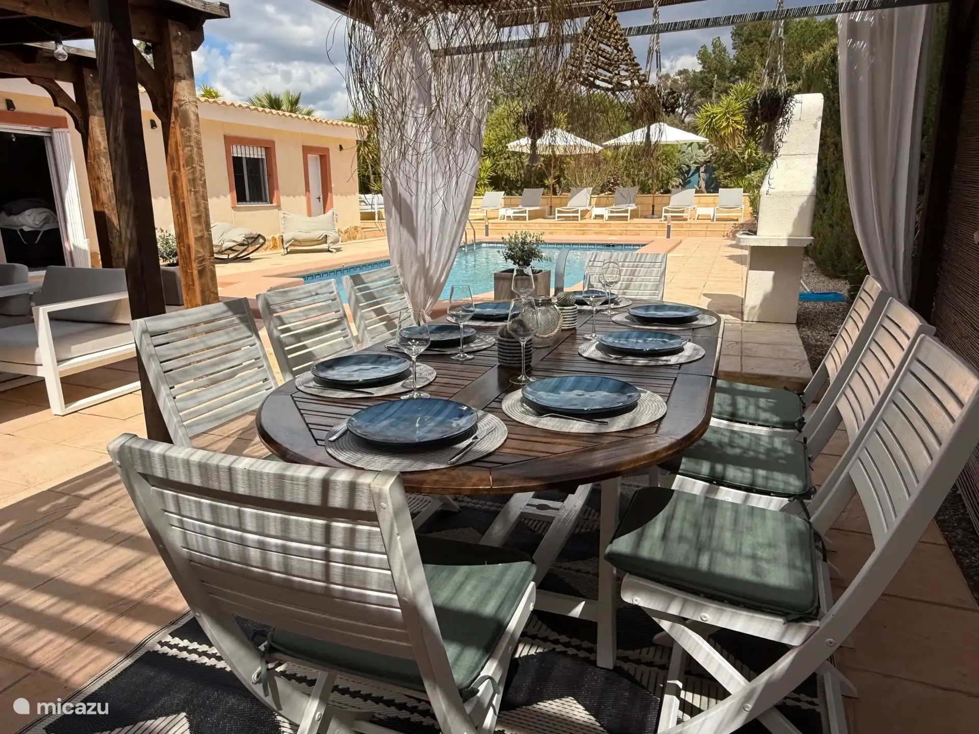 Unter der Veranda können Sie draußen mit Blick auf den Garten und den Pool essen