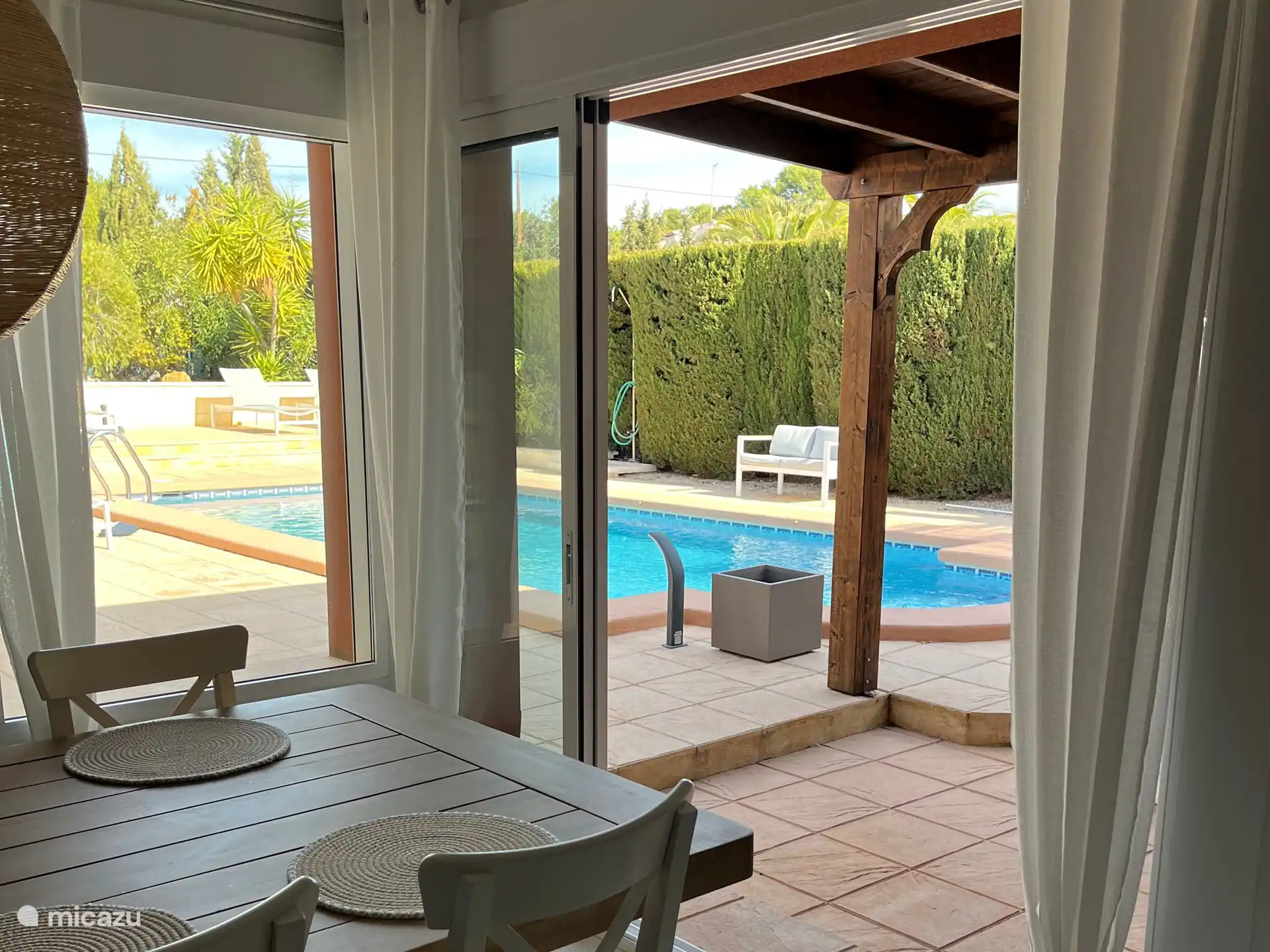 Das große Wohnzimmer (30 m²) verfügt über Schiebetüren zum Pool