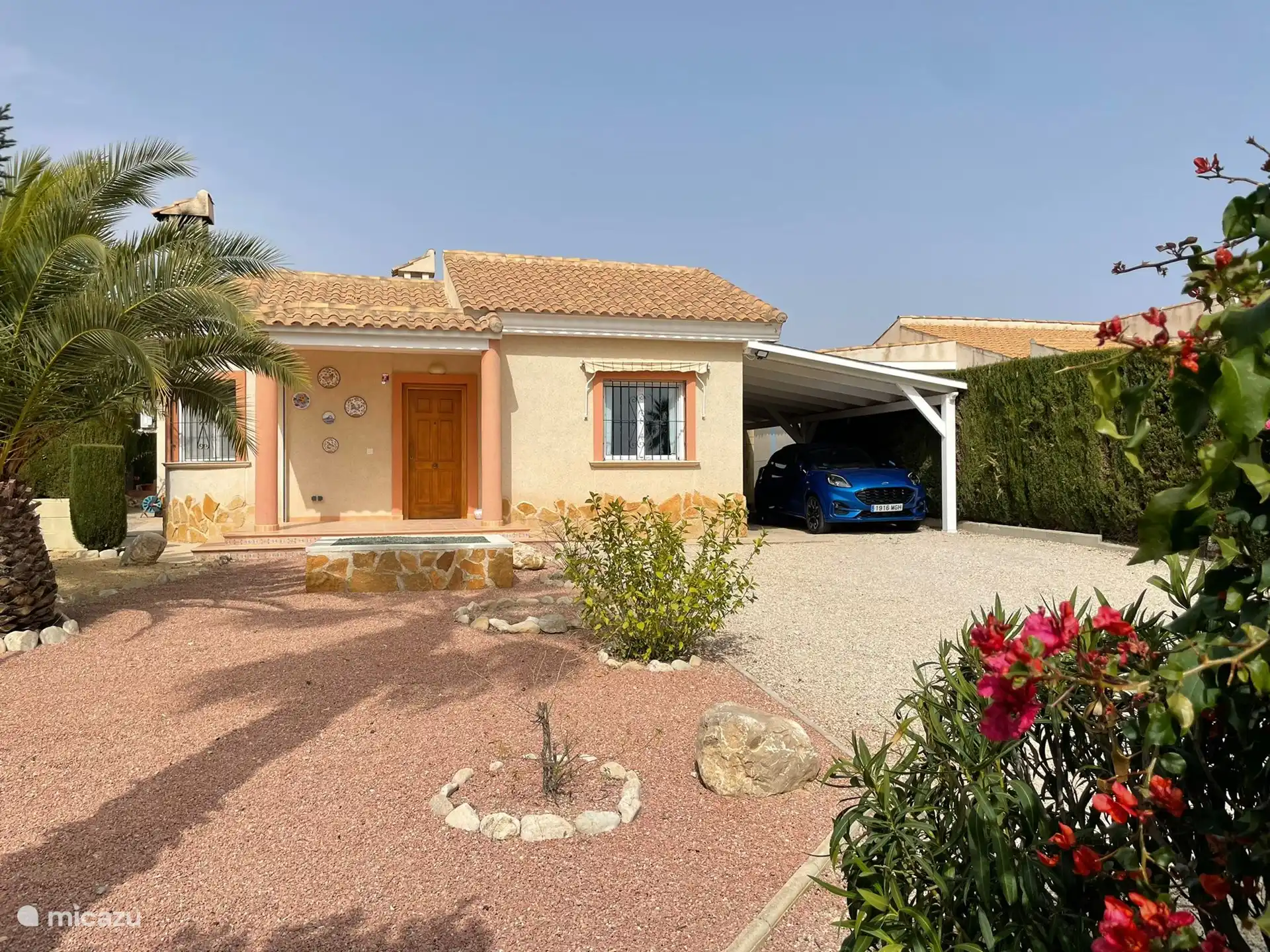 Das Foto von der Vorderseite der Ferienvilla mit einer großzügigen Auffahrt, die Platz für mehrere Autos bietet.