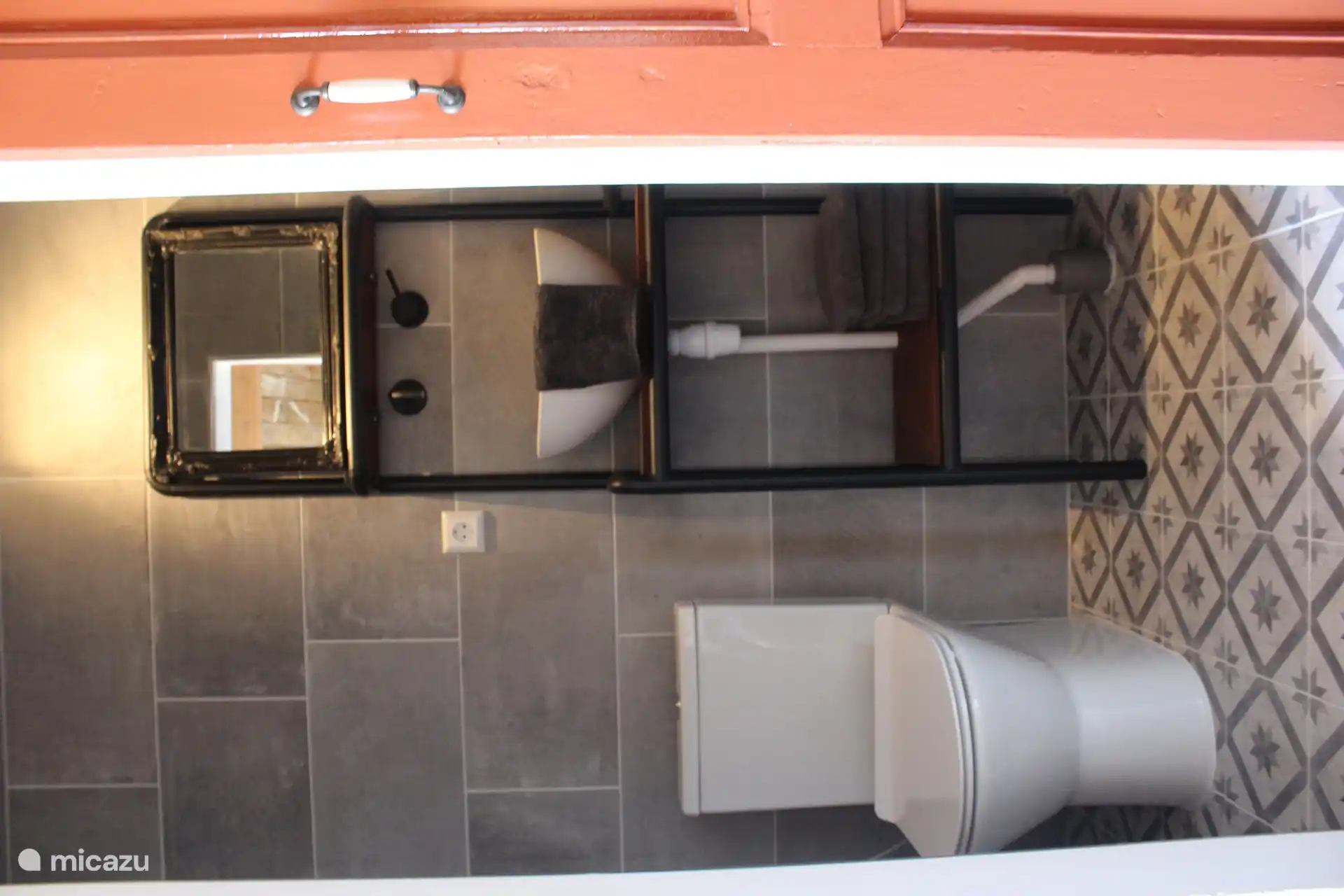 Kompaktes Badezimmer mit WC, Waschbecken und Dusche. 