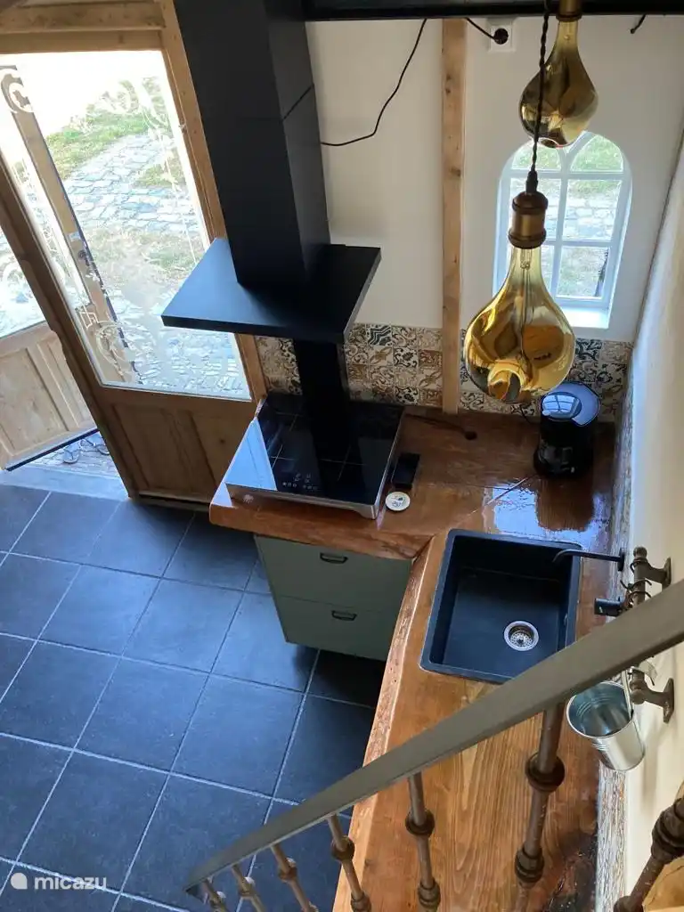 Kompakte Küche von oben, verfügt auch über einen kleinen Backofen zum Aufwärmen Ihrer Sandwiches, eine Filterkaffeemaschine, einen Wasserkocher, ein Induktionskochfeld und einen Kühlschrank.