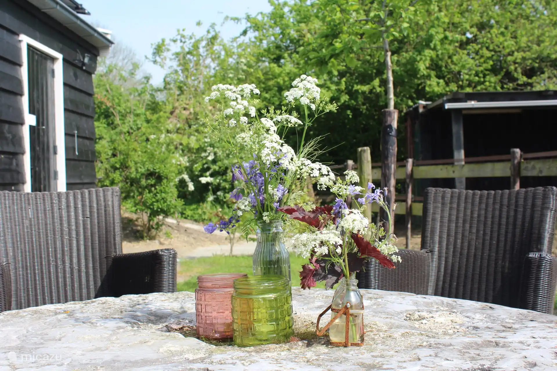 Im Frühling und Sommer lässt es sich wunderbar draußen unter dem Sonnenschirm sitzen. Der Tisch ist ein alter Mühlstein.