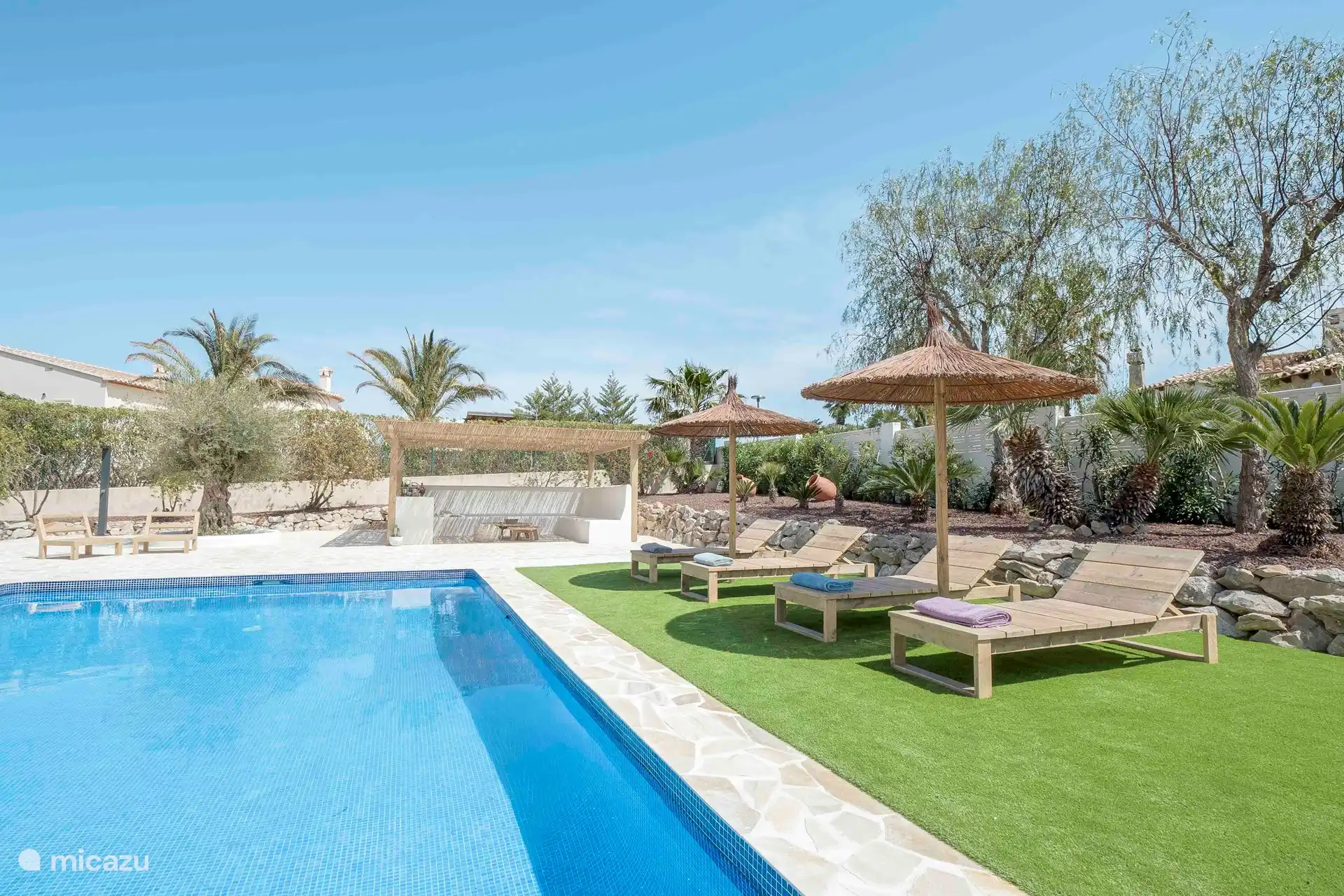 Casa d'Olivera - Zwembad met ligstoelen en parasols.