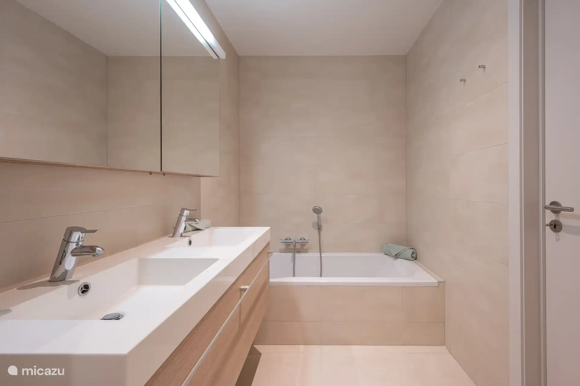 Badezimmer mit Badewanne, WC-Schrank, Doppelwaschbecken, WC, Handtuchtrockner und Dusche