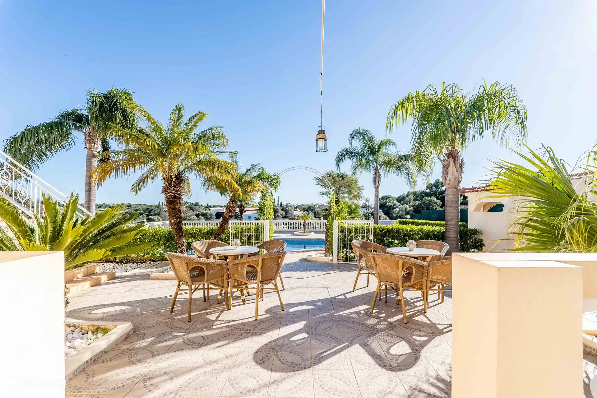 Entspannungsbereich zwischen Pool und Haus