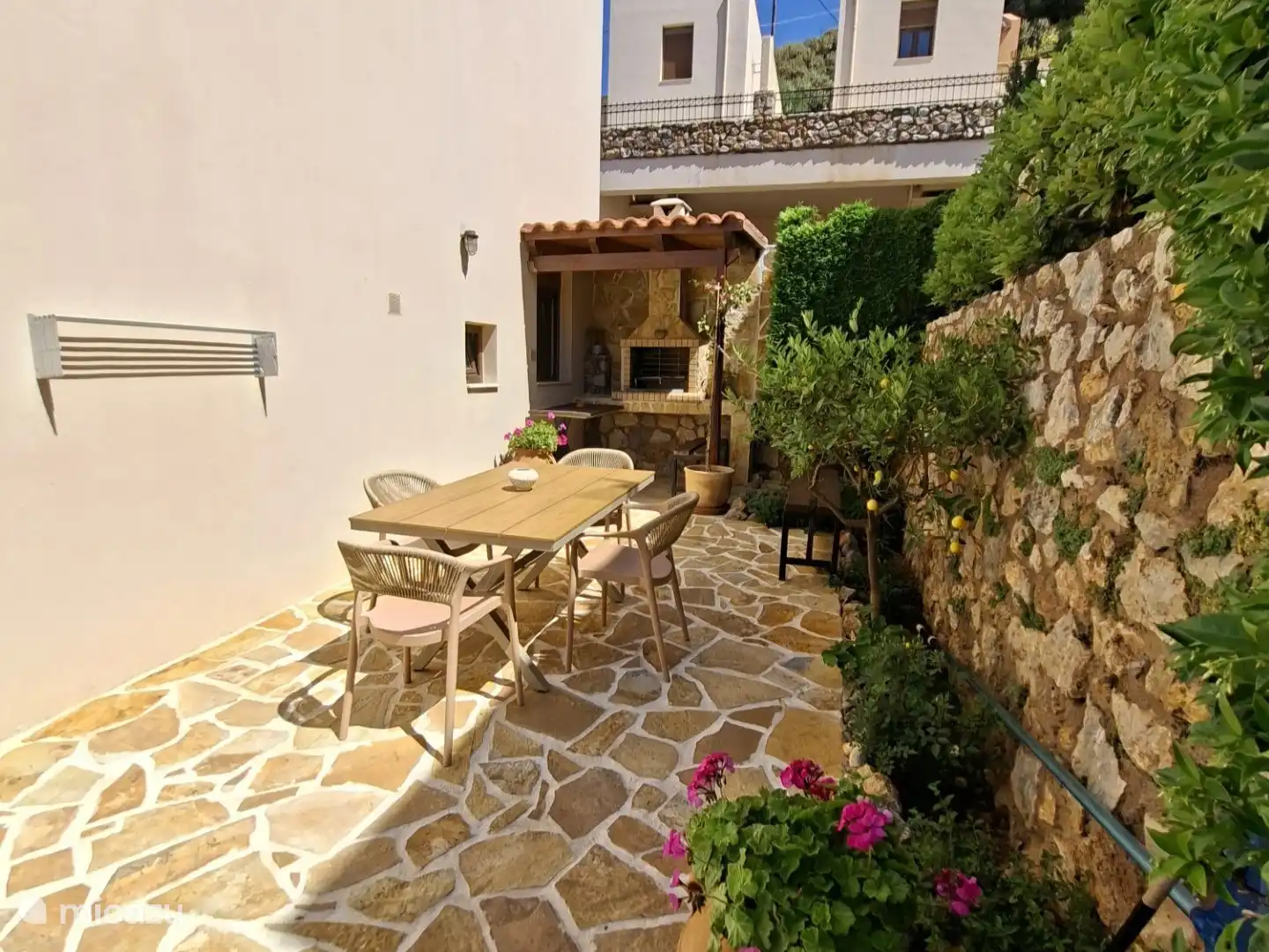Seitenhaus mit Sitzbereich und Grill