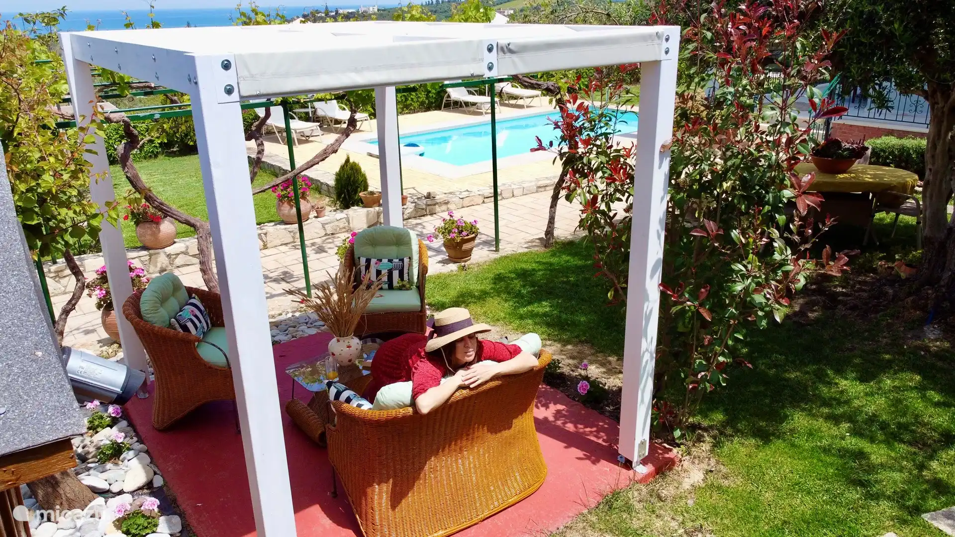 Teil des Gartens mit einem Essbereich unter der Pergola 