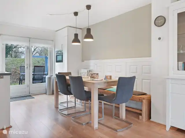 Chisporrotea en Países Bajos, Holanda Meridional, Ouddorp - casa vacacional La mesa de comedor junto a la cocina y una vista del horno y el refrigerador y el amplio armario de la farmacia