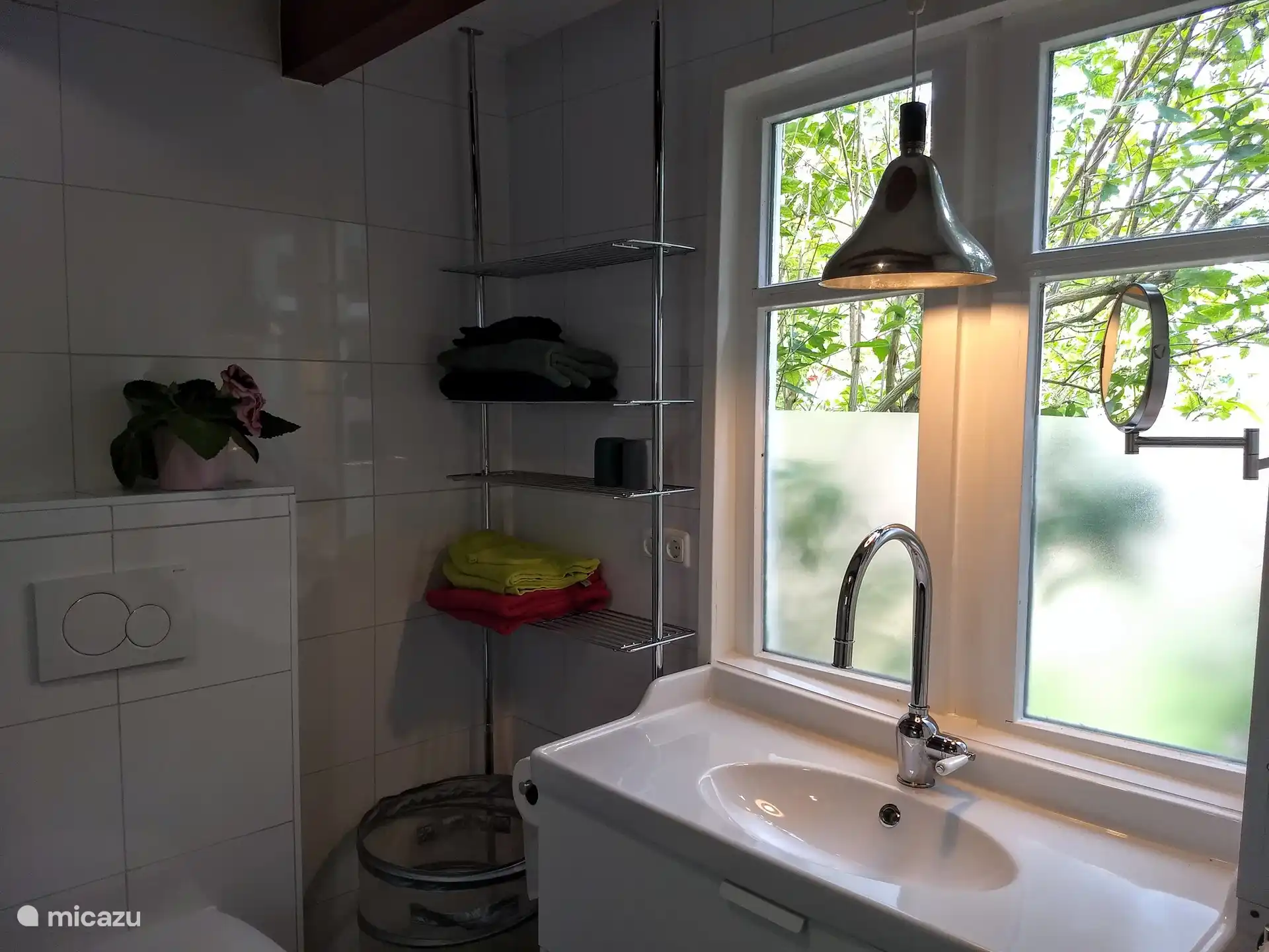 Rechts vom Waschbecken befindet sich eine Waschmaschine/Trockner.