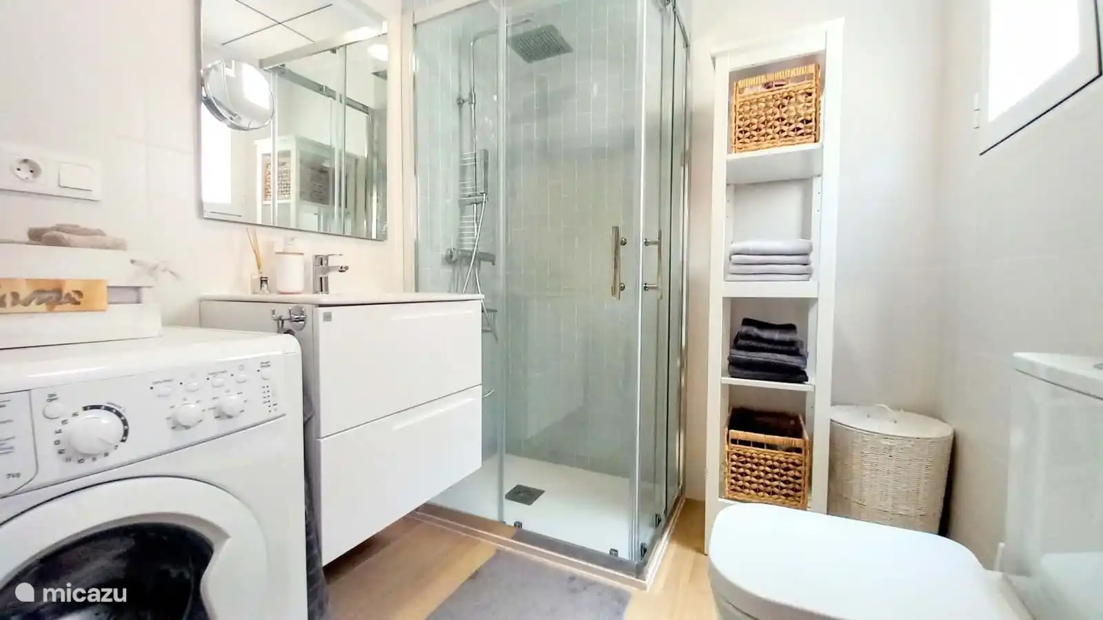 Badezimmer mit WC, Dusche und Waschmaschine. 