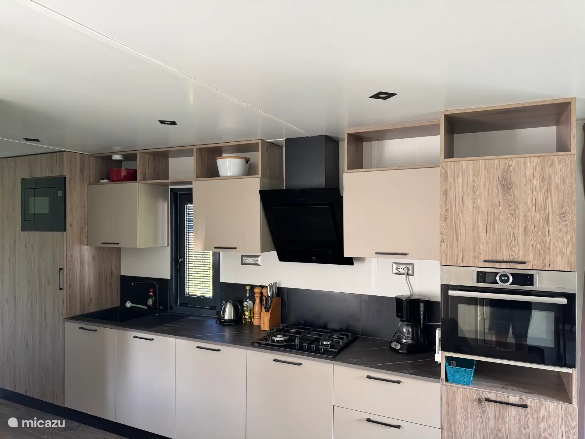 Cuisine de luxe avec four mixte à convection Bosch, lave-vaisselle, deuxième micro-ondes et cuisinière à quatre brûleurs et malgré un large choix de vaisselle et d’ustensiles de cuisine, beaucoup d’espace de rangement