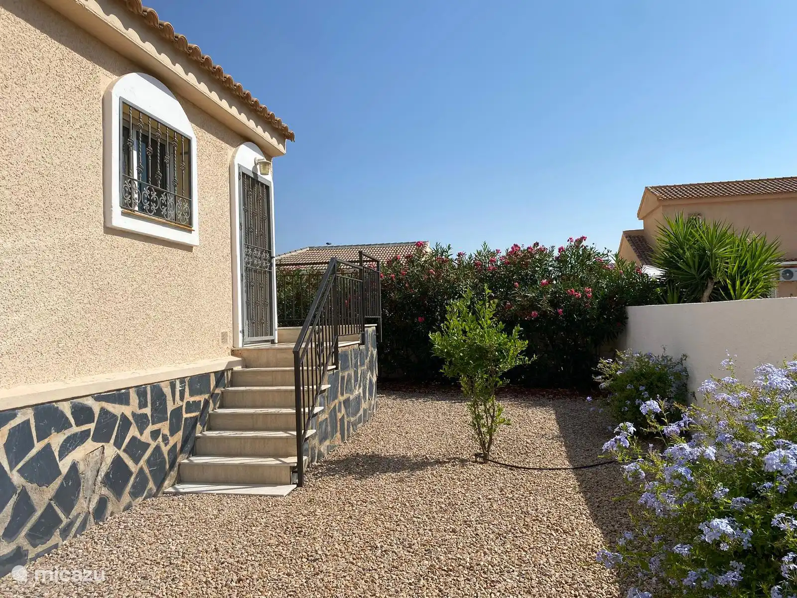 Die Seite des Hauses mit der Tür zur Küche und der Treppe nach oben