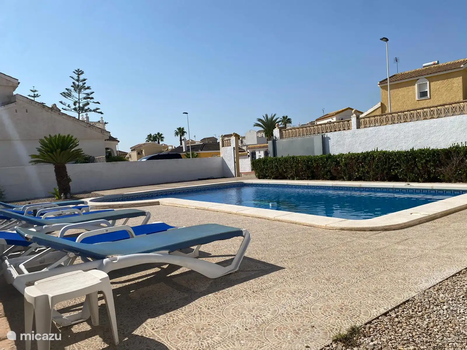 Eingezäunter Garten mit Swimmingpool und Liegestühlen