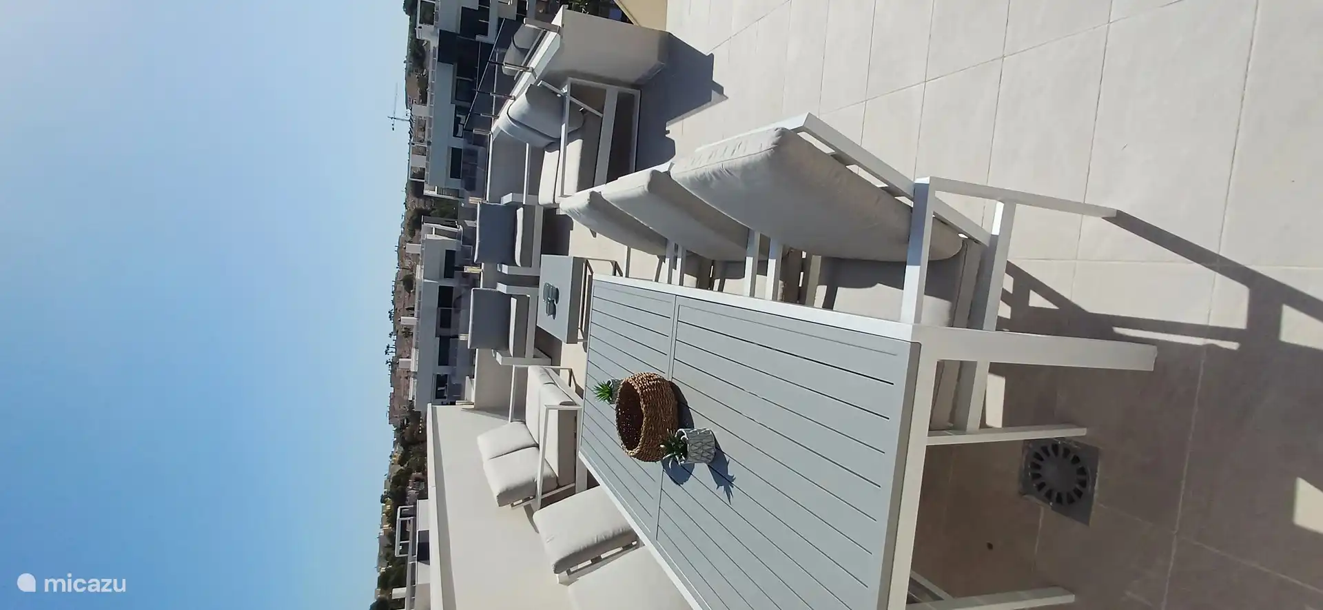Una amplia terraza en la azotea con sala de estar, tumbonas y muebles de jardín para disfrutar en cualquier momento del día