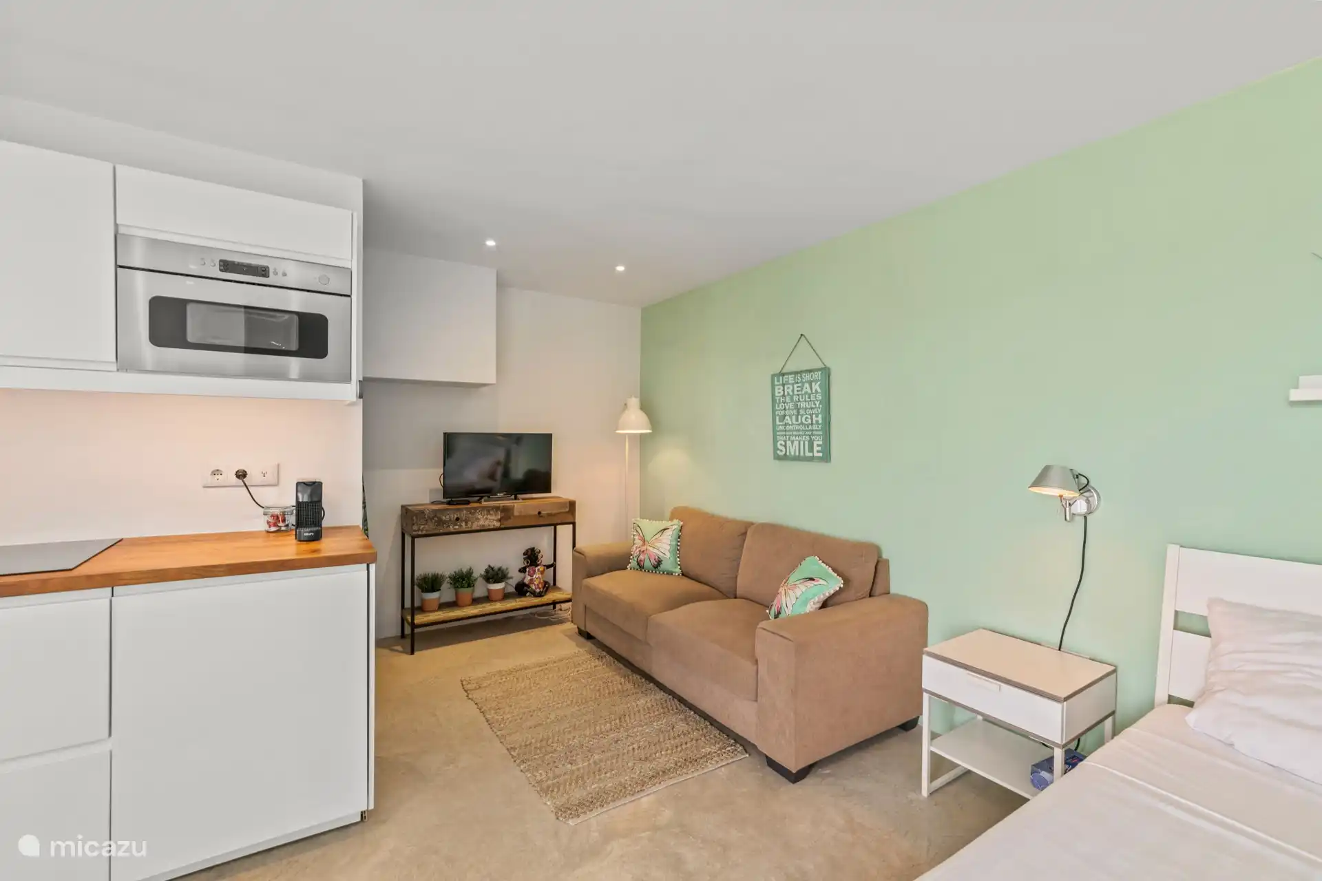 Bequemes Sofa neben dem Fernseher.