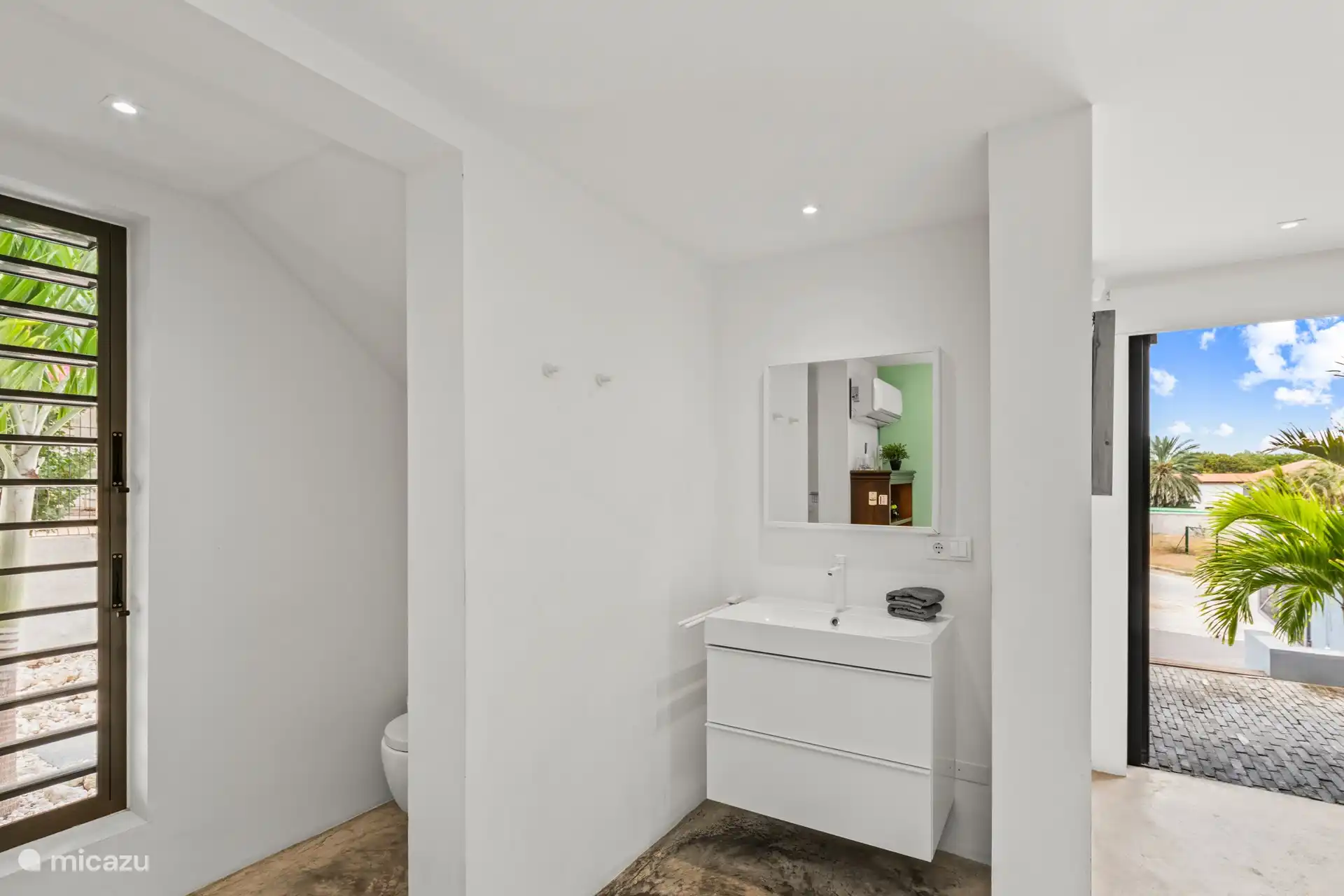 Offenes Badezimmer mit WC, Waschbecken und Dusche.