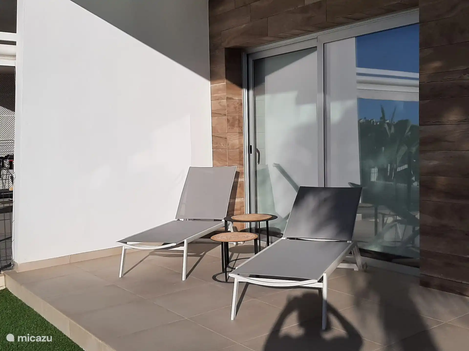 Una agradable terraza con 2 tumbonas