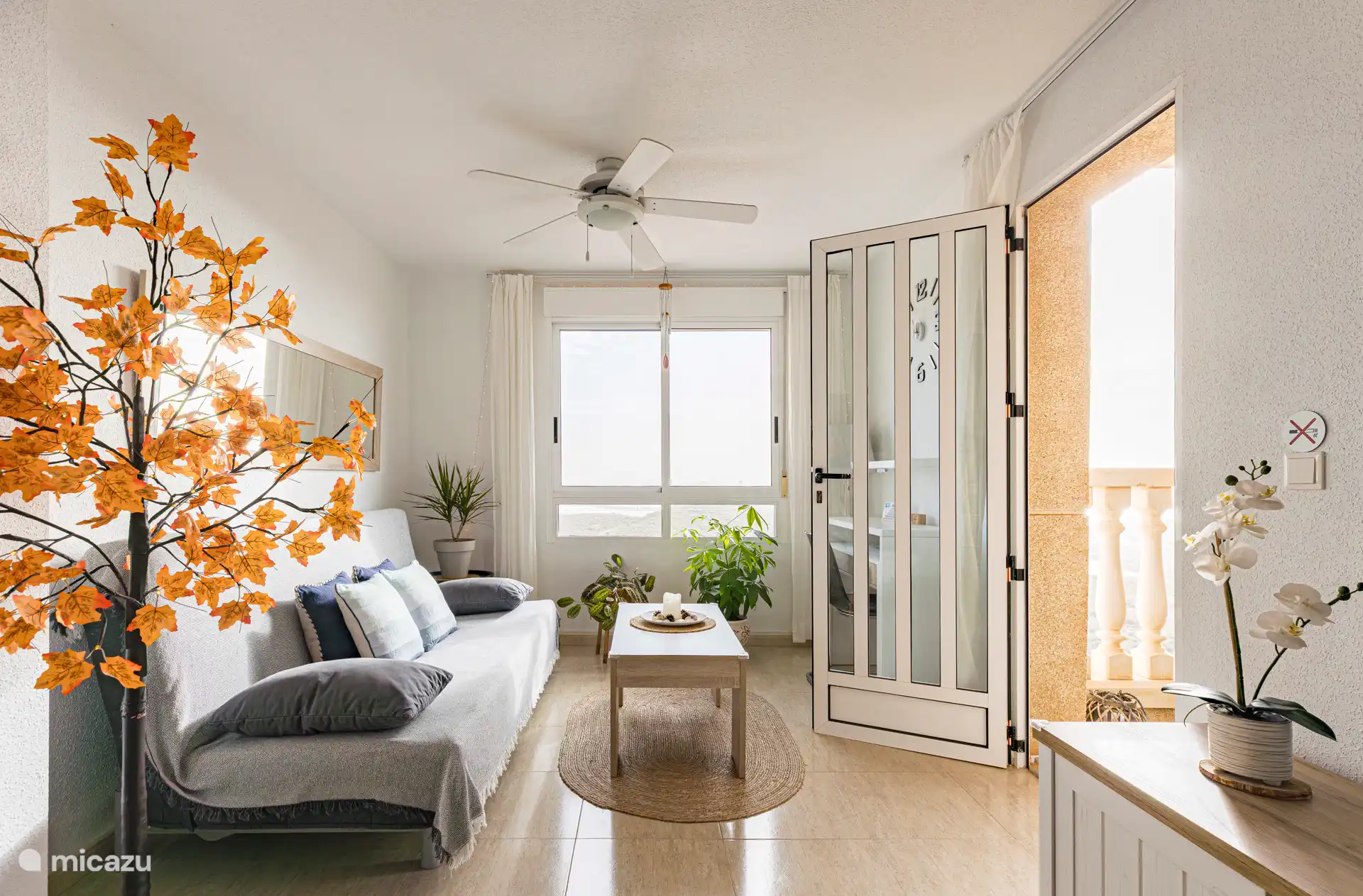 Salon avec canapé-lit et vue sur la mer, les montagnes et la ville.