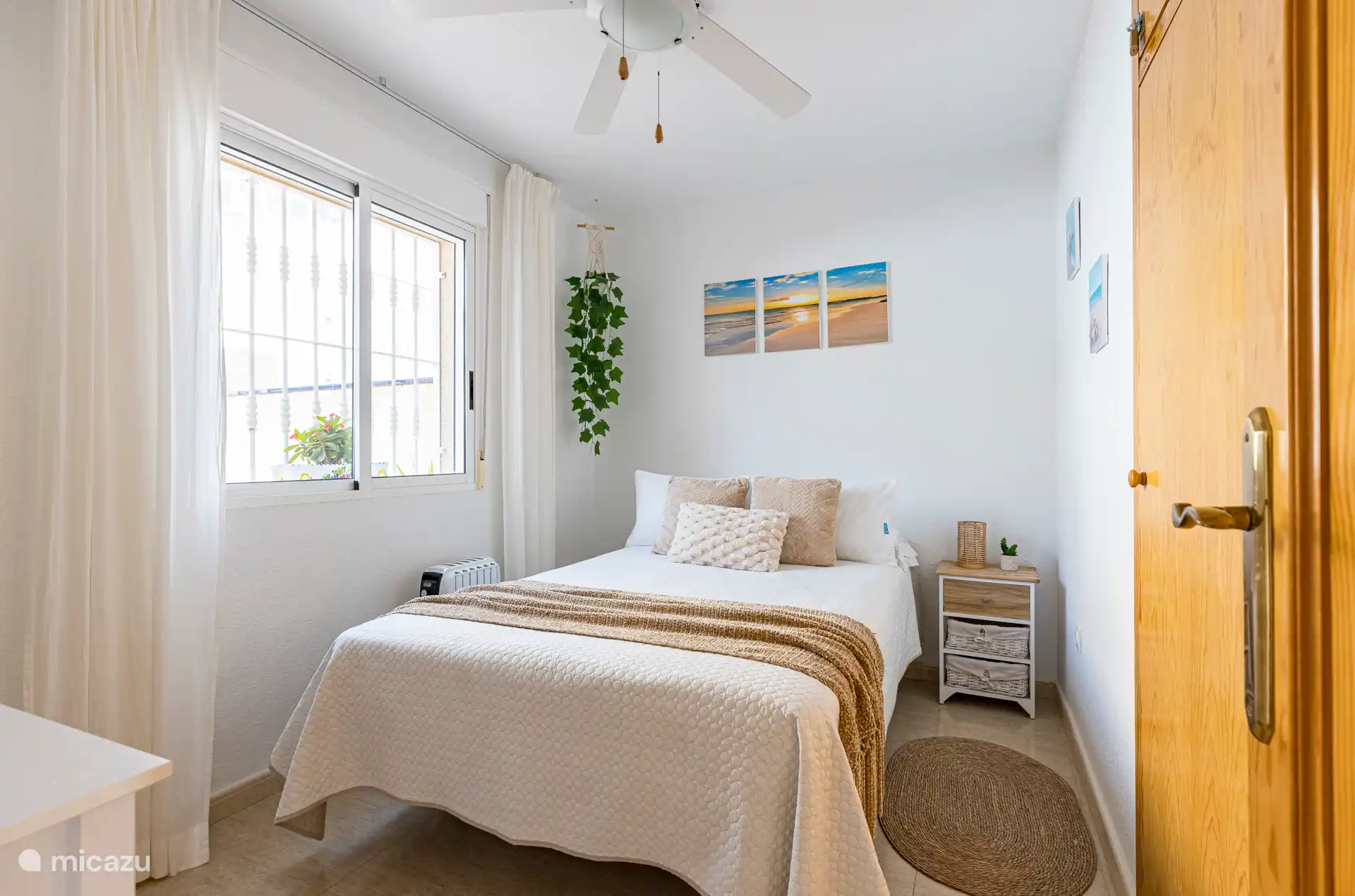 Deuxième chambre, avec vue sur la rue, ventilateur de plafond, radiateur, armoire pour ranger des vêtements, cintres, très lumineux.