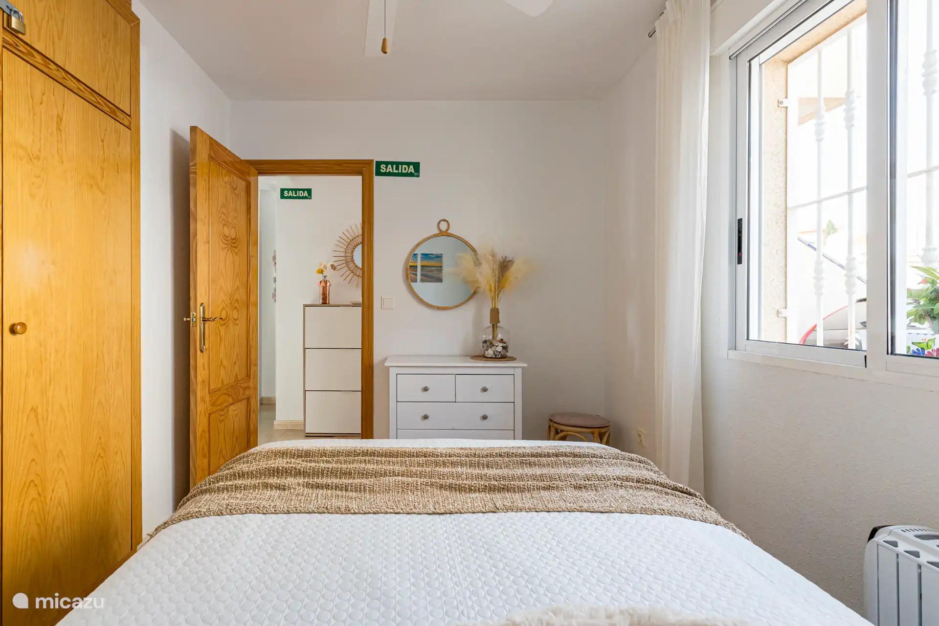 Deuxième chambre avec vue sur la rue et parking, attenant à l’entrée principale. Détails de l’hébergement.